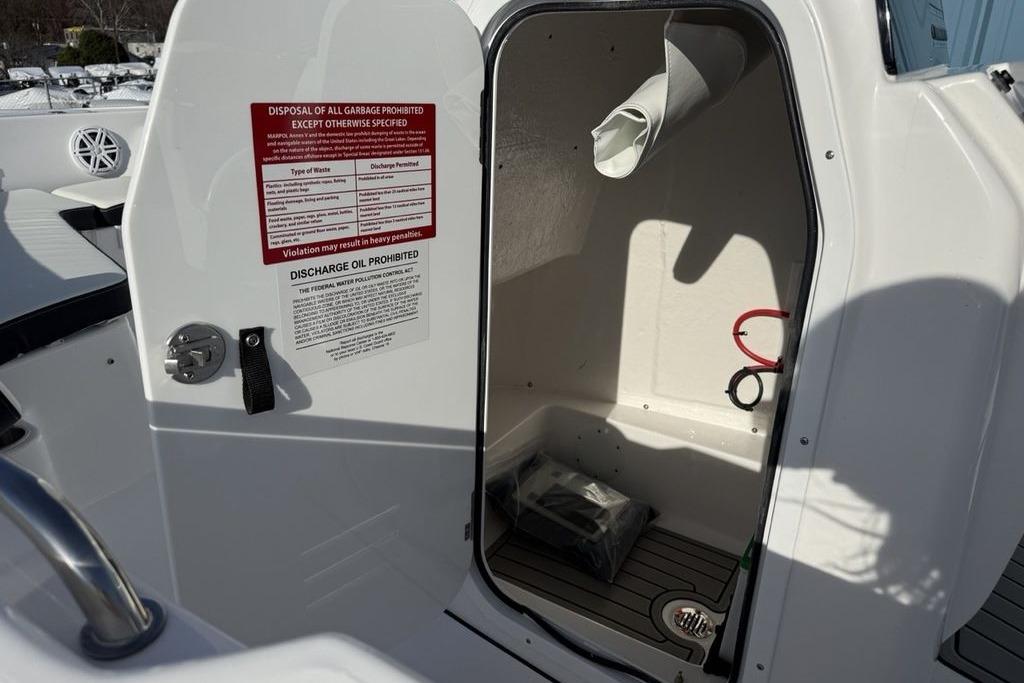 Open storage compartment on 2026 Tidewater 198 CC Adventure boat with safety notices.