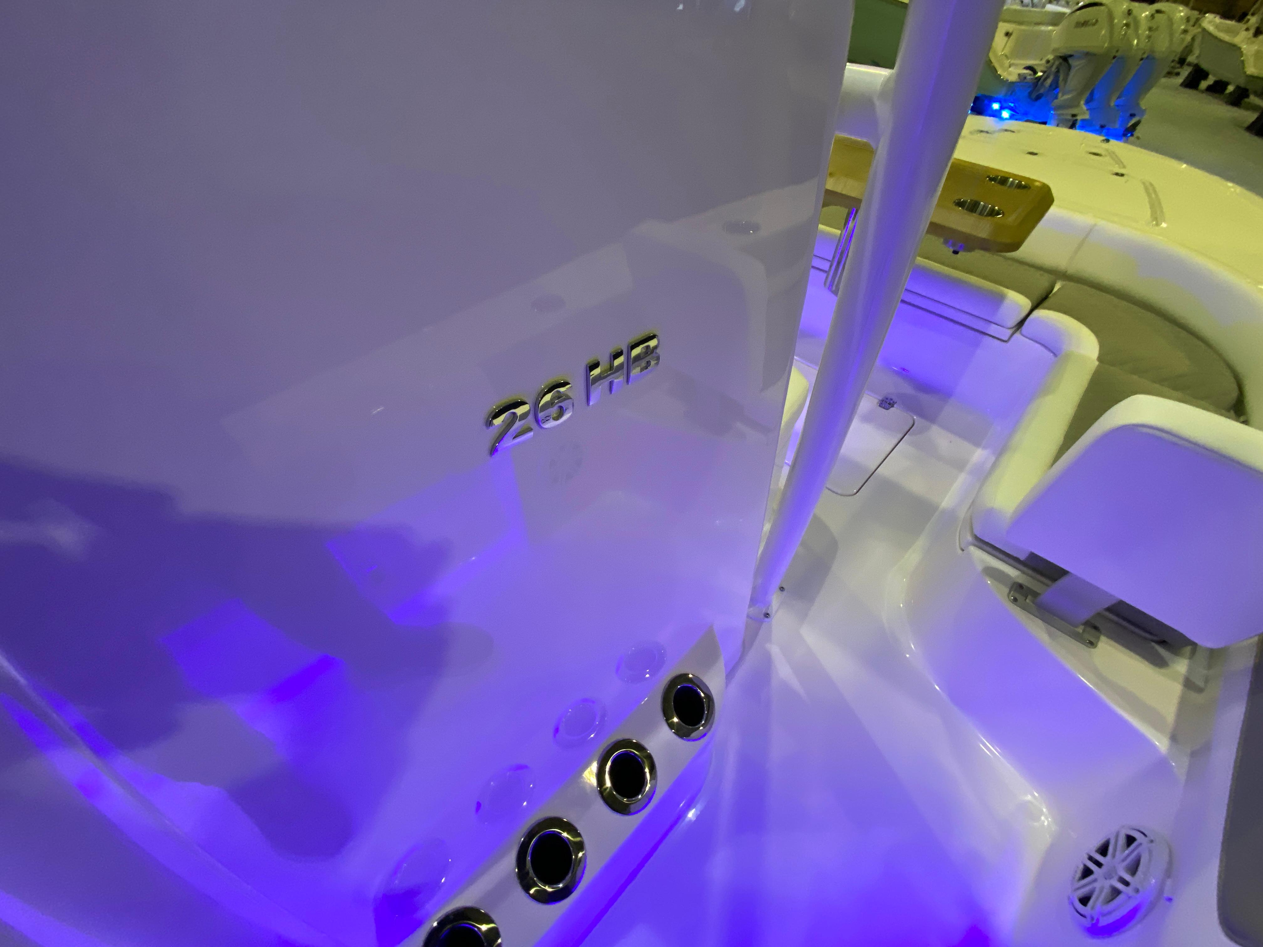 2025 Caymas 26 HB boat interior with blue lighting and seating area.