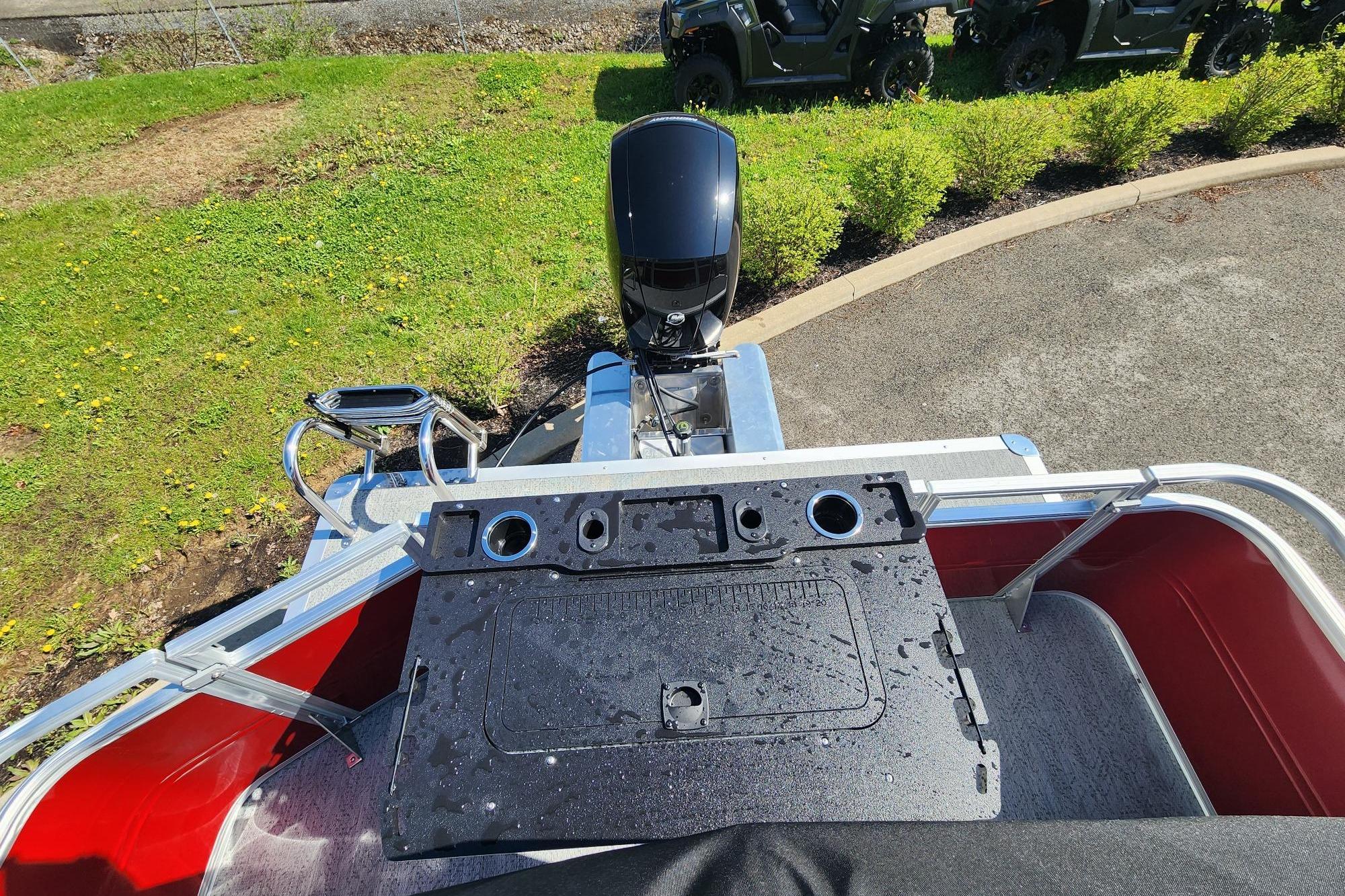 2026 Sun Tracker Fishin' Barge 22 DLX with motor, viewed from above, on a sunny day.