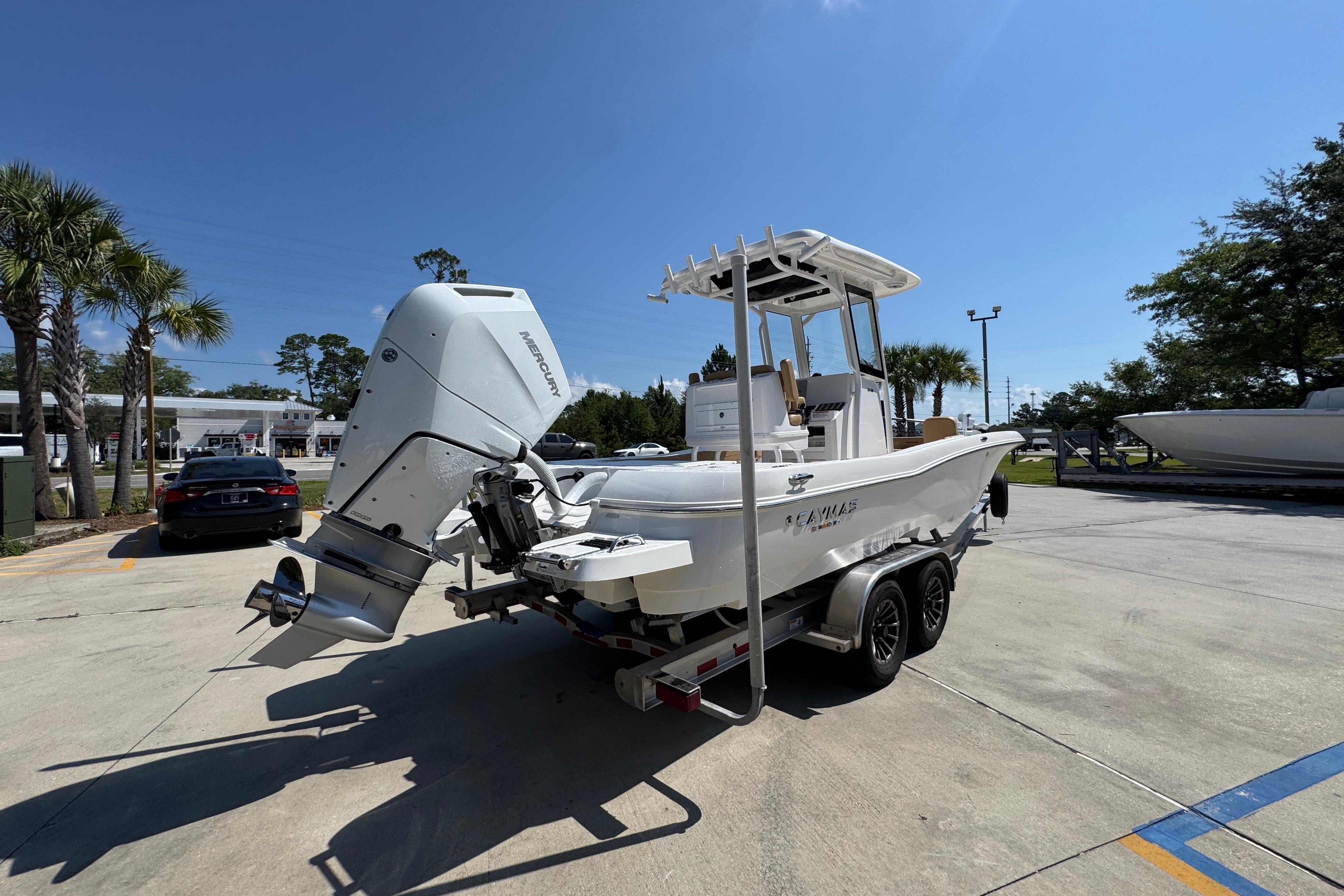 2027 Caymas 26 HB boat on trailer with Mercury outboard engine, parked outdoors.