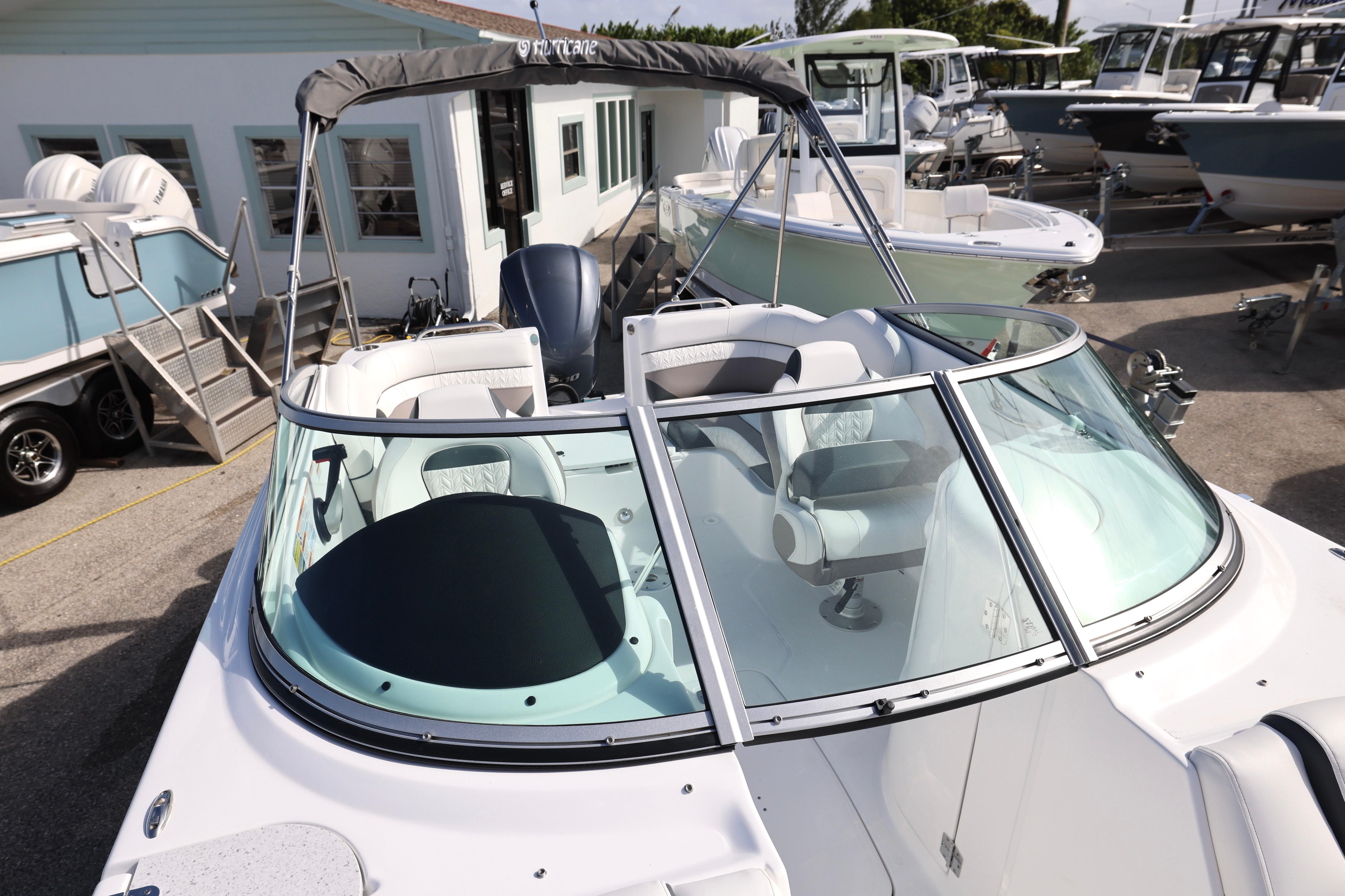 2026 Hurricane SunDeck 2486 OB boat with sleek design, docked at a marina.