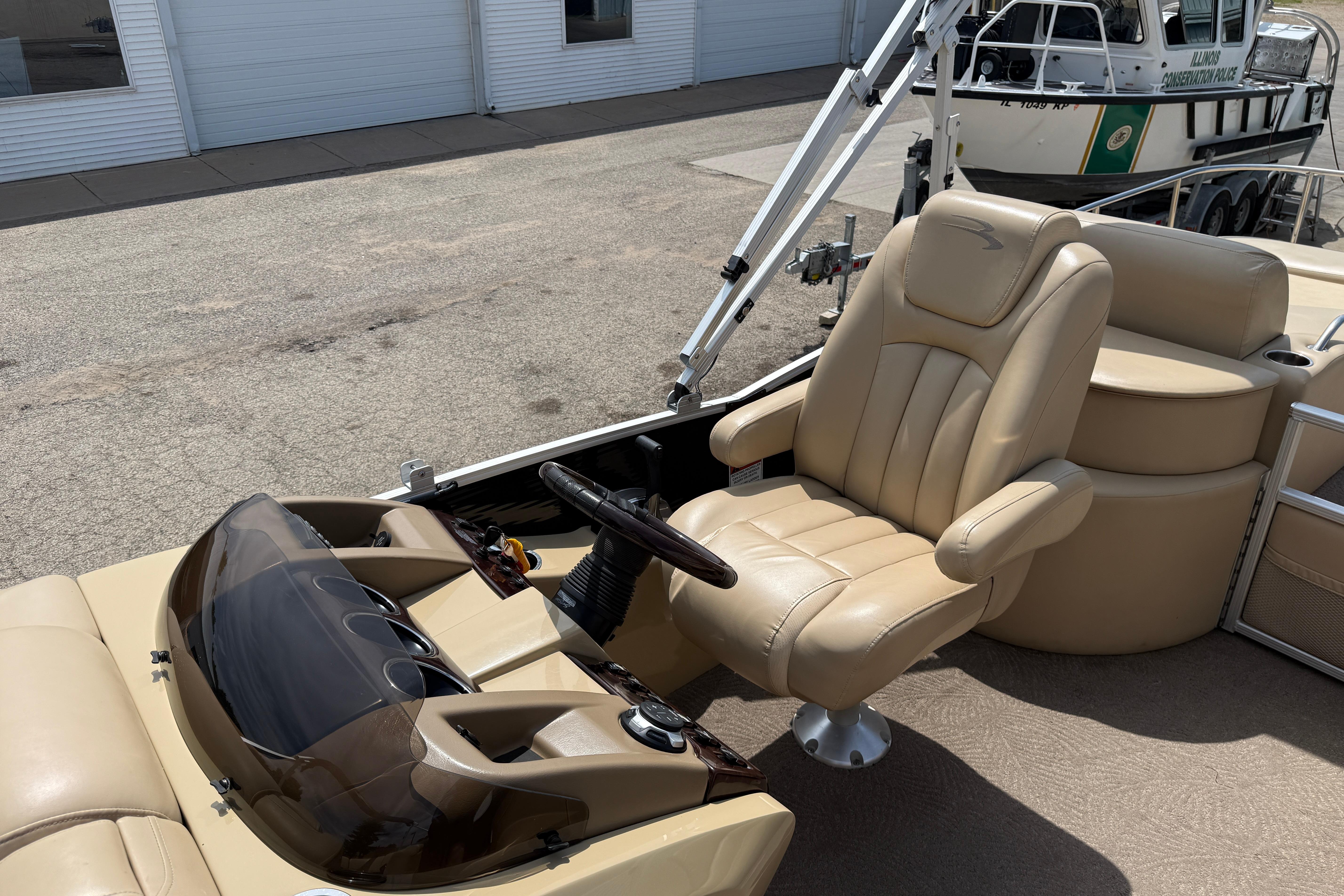 2011 Bennington 2575QCW I/O boat with beige captain's chair and steering console.