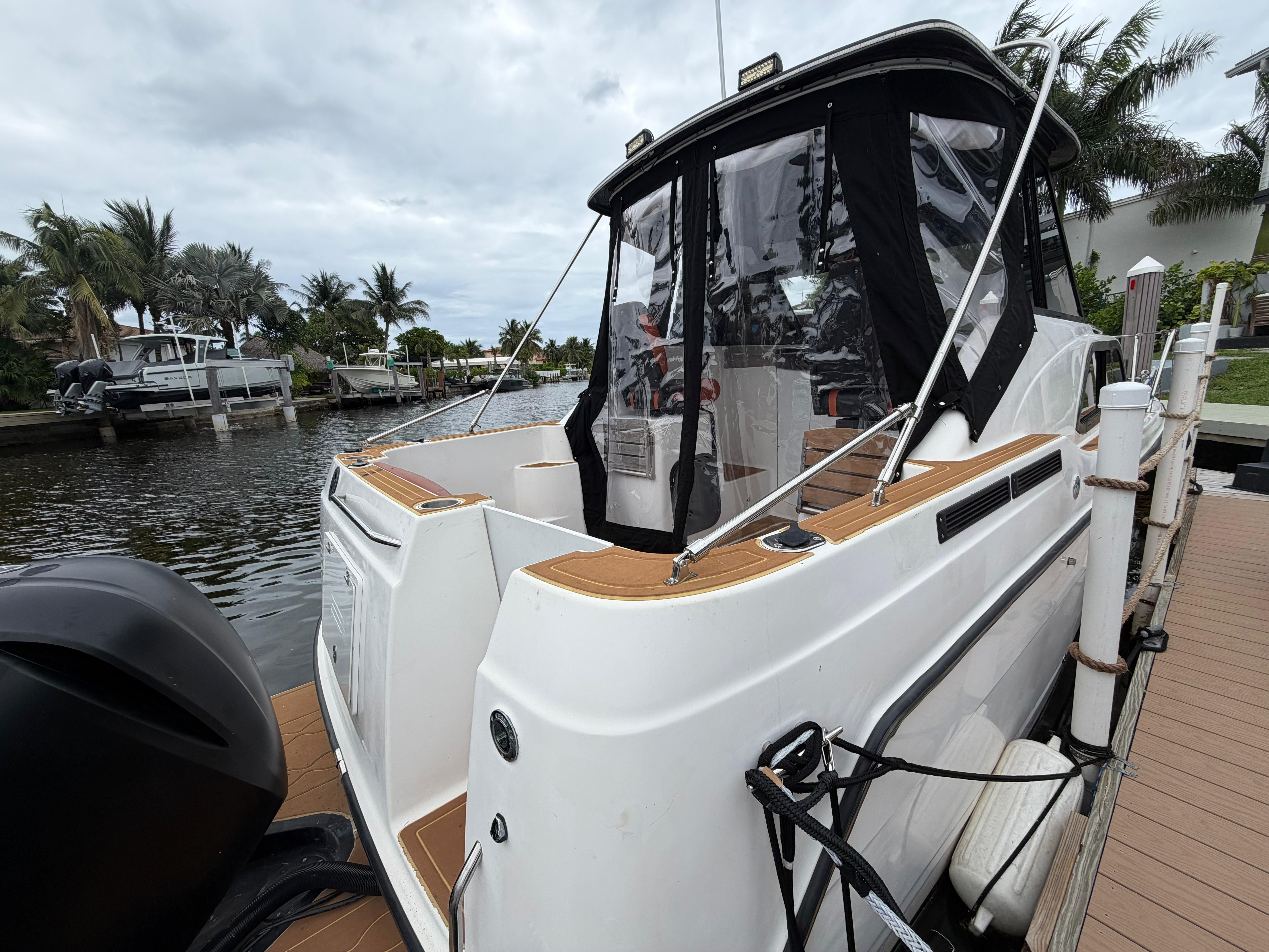 2001 Bayliner 2452 Ciera Classic docked with palm trees in the background.