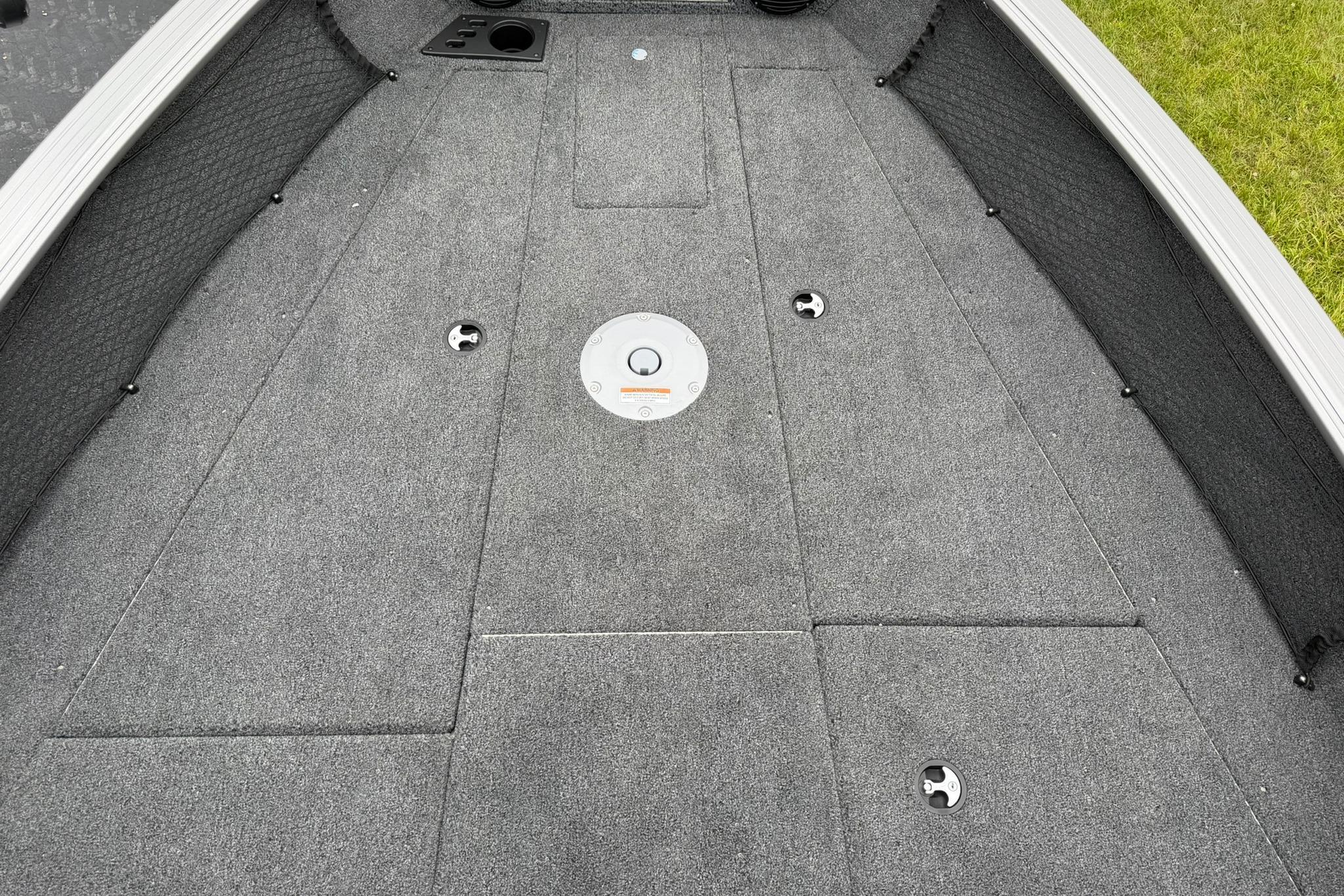 2027 Lund 2075 Impact XS boat deck with gray carpeting and storage compartments.