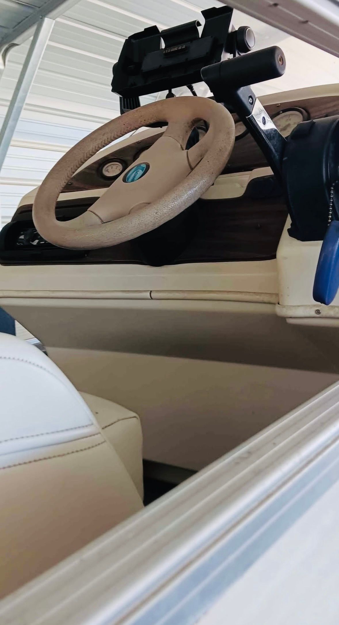 Interior view of a boat with steering wheel and dashboard.