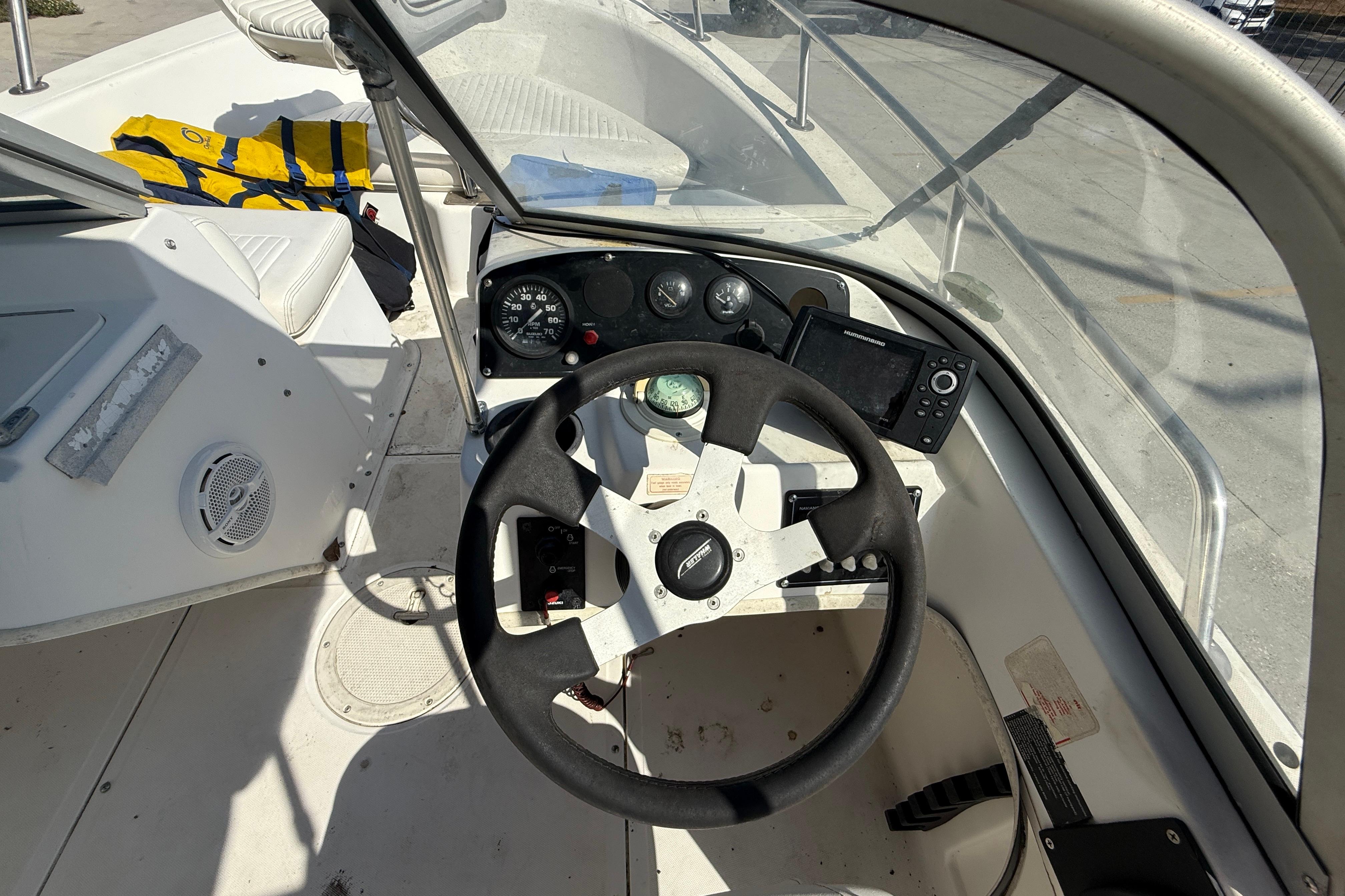 2002 Boston Whaler Ventura 160 boat cockpit with steering wheel and navigation instruments.