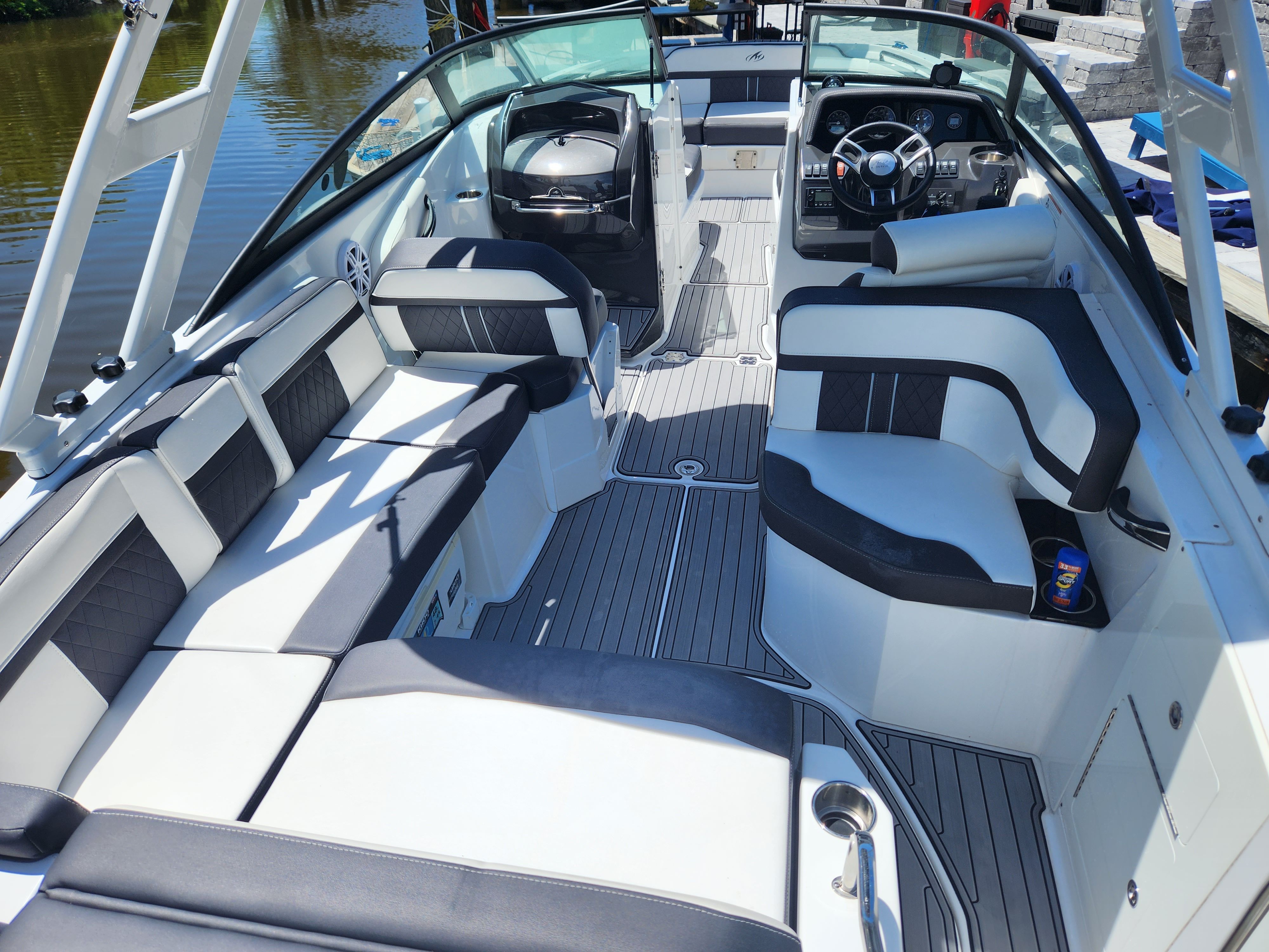 Interior of a 2021 Monterey M6 boat with sleek black and white seating and a modern dashboard.