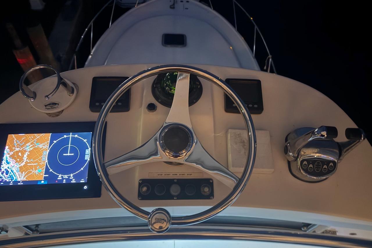 Helm of 2002 Pursuit 3800 Express boat with navigation screens and controls.
