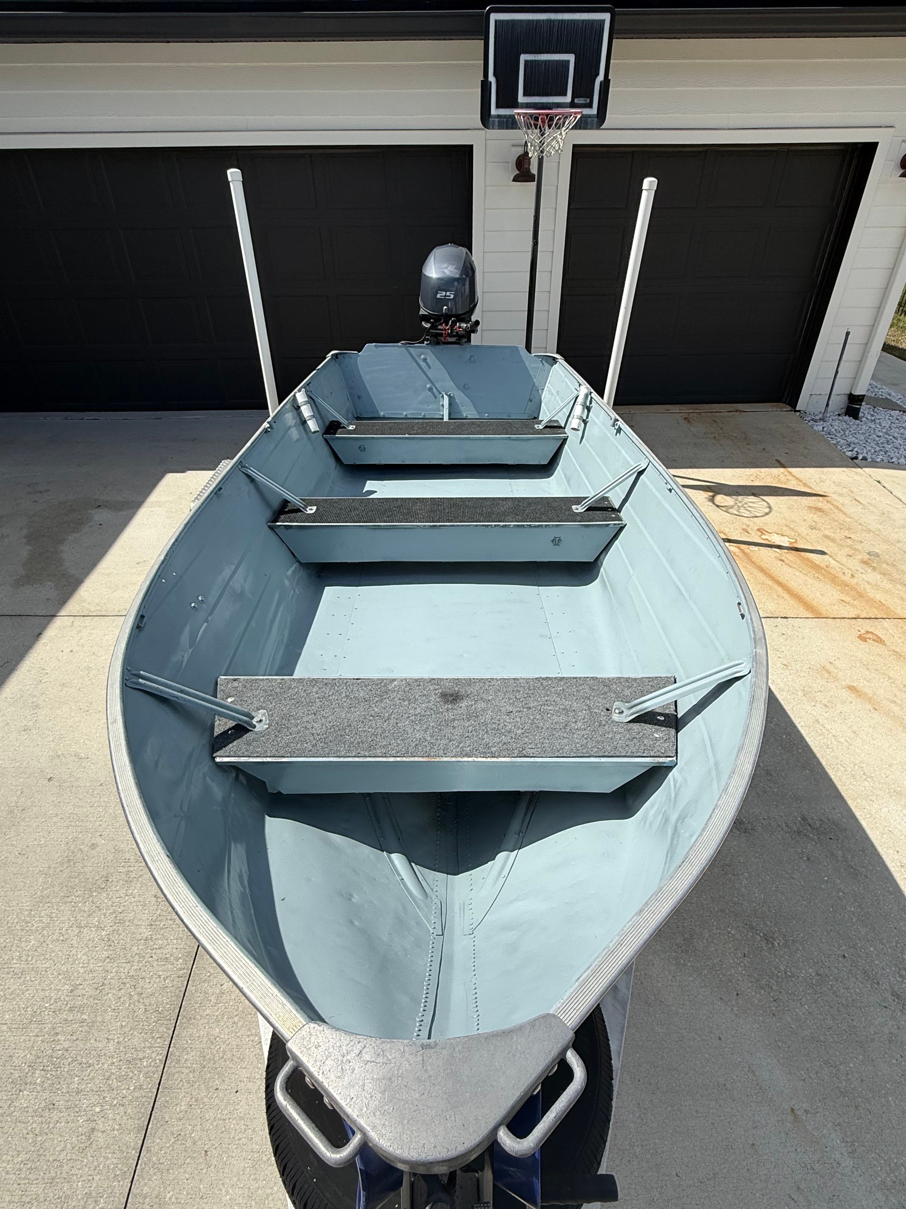 A 1977 Smoker Craft boat with a deep V hull and side console, parked on a trailer.