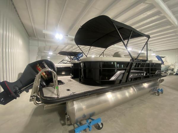 2024 Starcraft EXS 1 pontoon boat in showroom with Yamaha outboard motor.