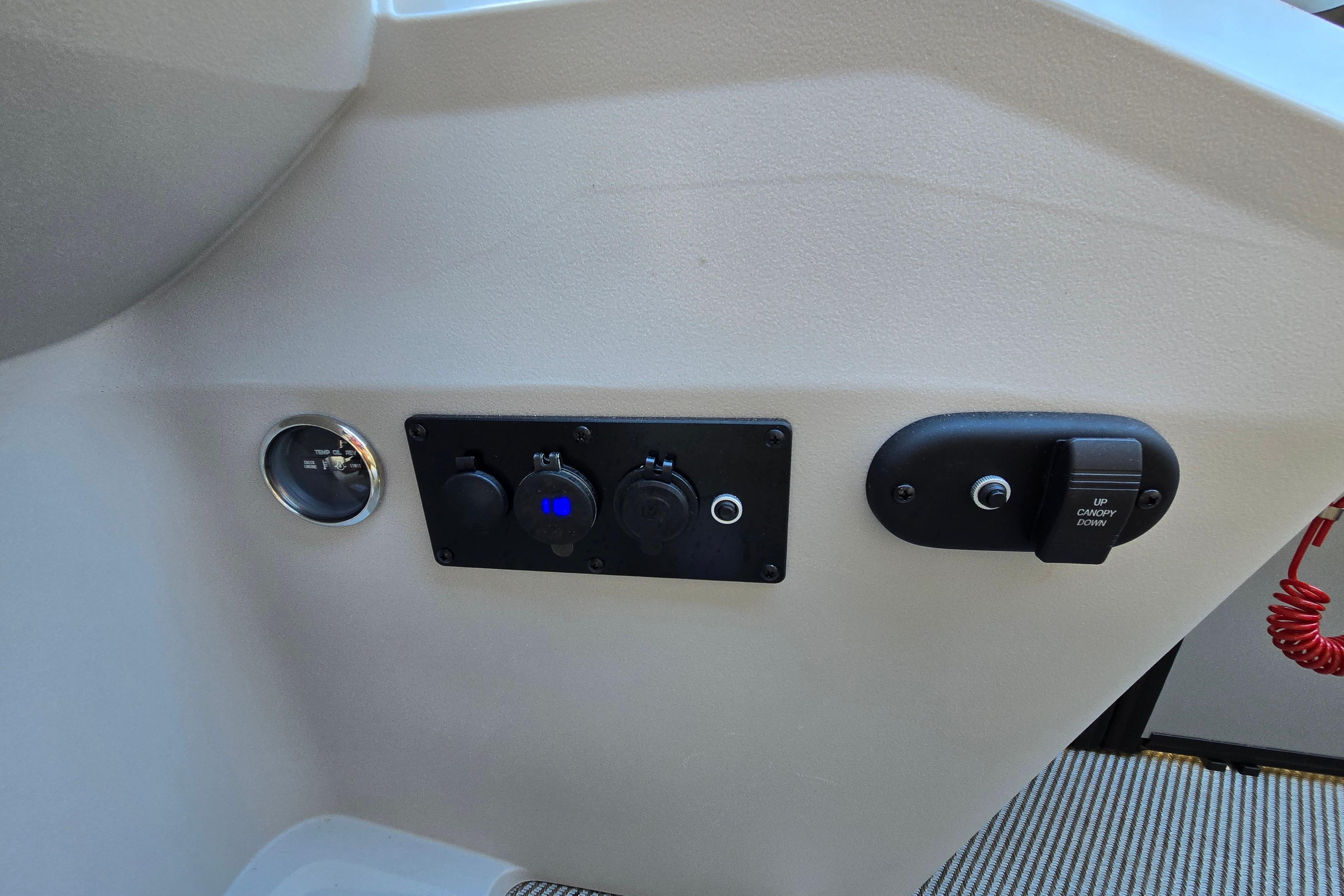 Control panel of 2024 Godfrey Sweetwater 2486 SB boat with switches and gauge.