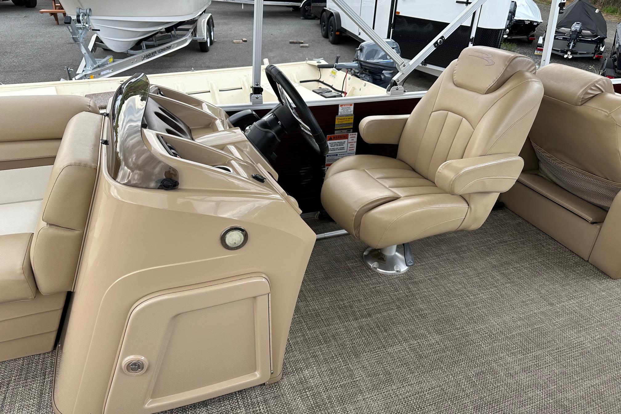 2016 Bennington 24 SCWX boat interior with beige captain's chair and dashboard.