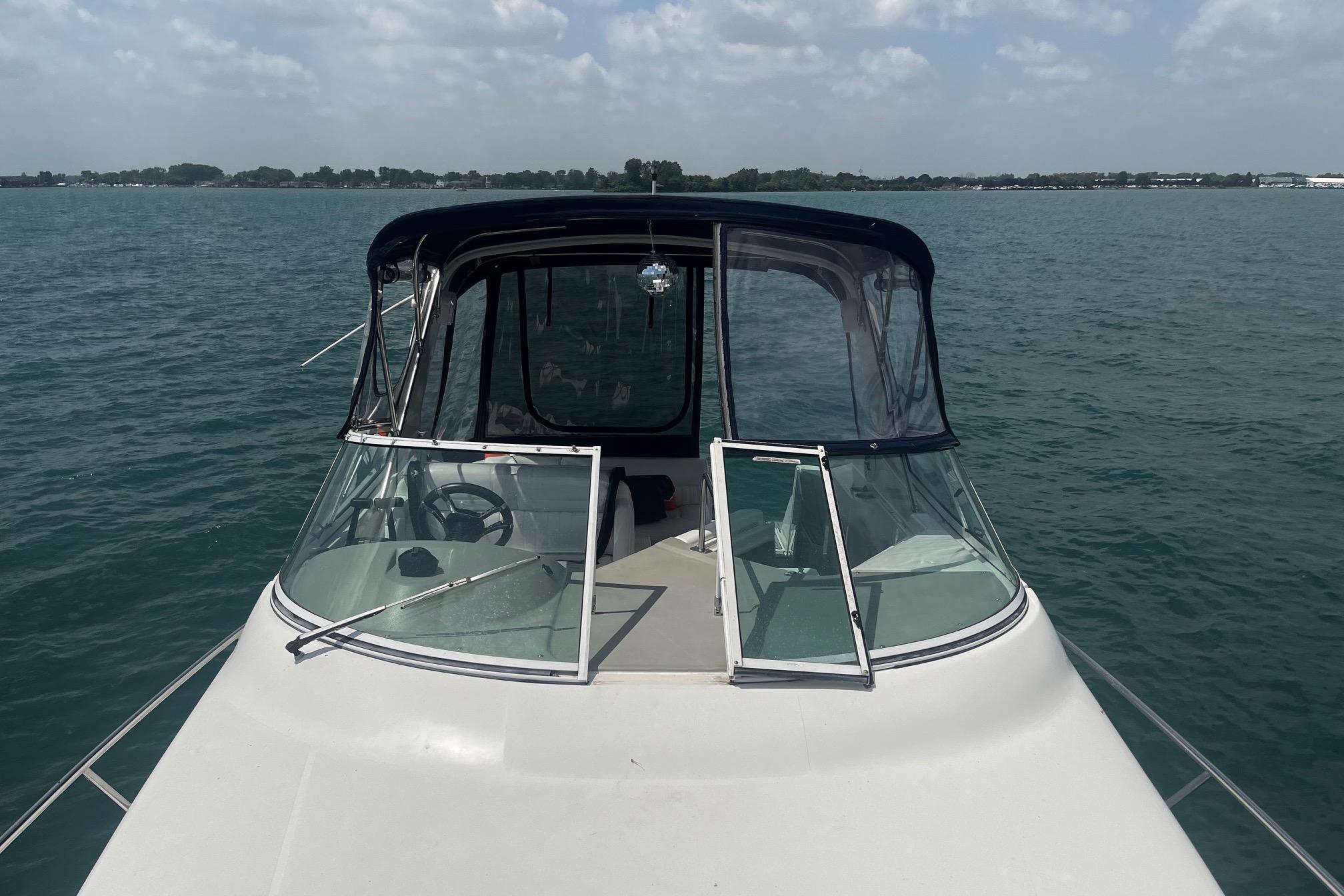 2004 Cruisers Yachts 280 CXi Express on calm water, featuring a sleek design.