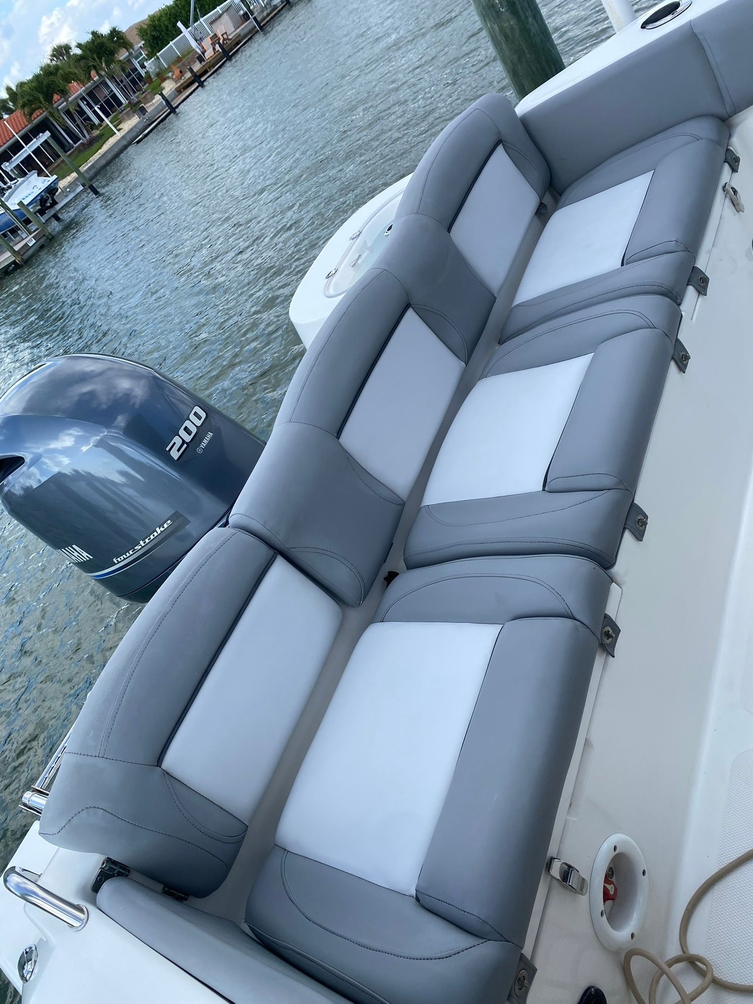 2021 NauticStar Legacy boat with gray cushioned seats by the water.