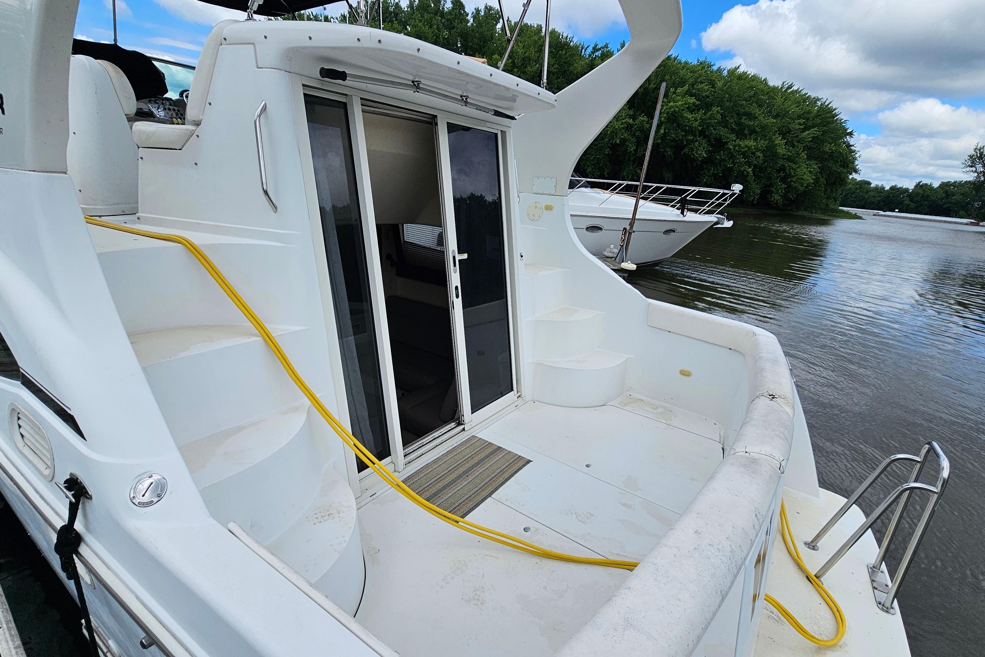 1999 Carver 350 Mariner yacht with open deck, docked by a serene river.