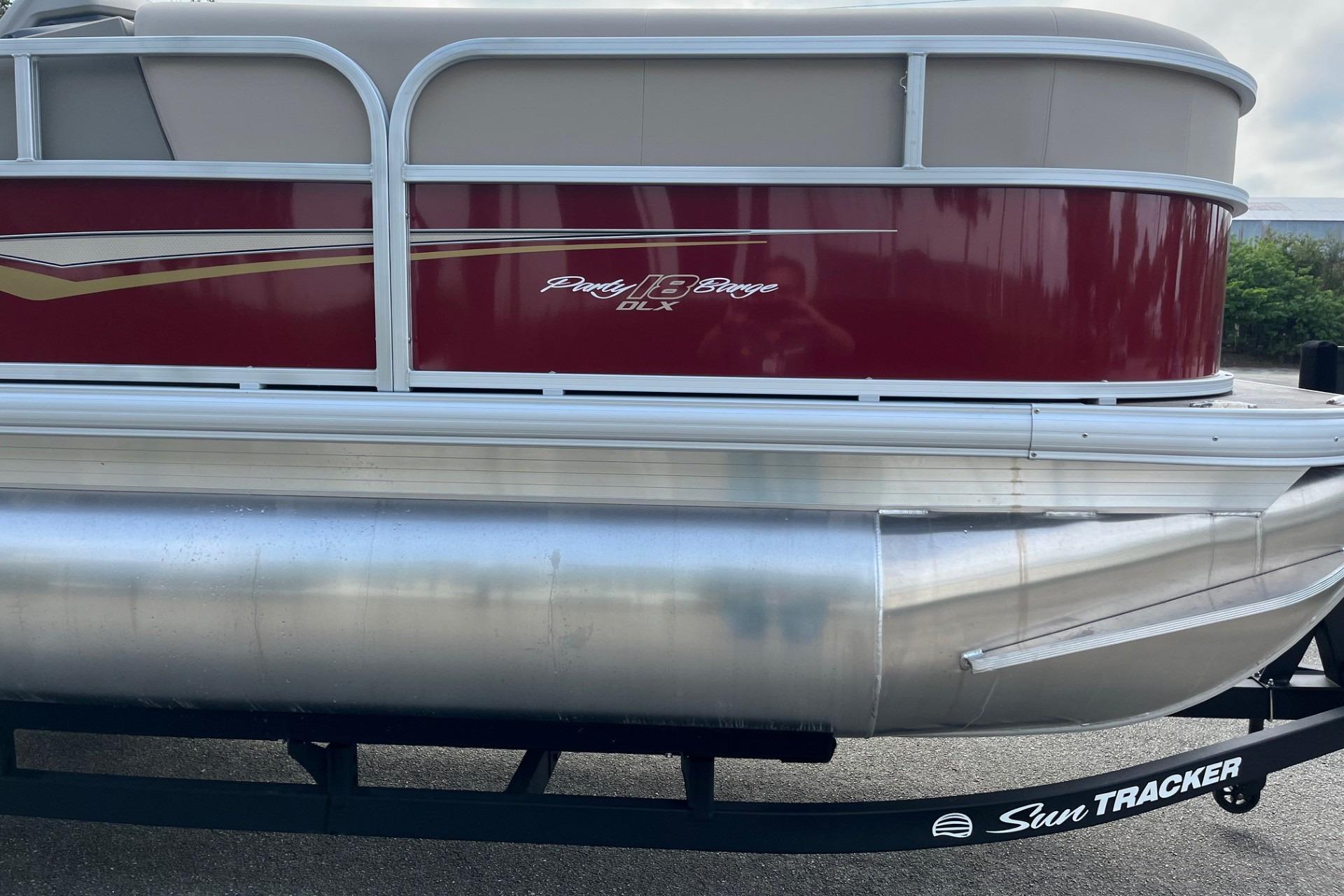 2025 Sun Tracker Party Barge 18 DLX pontoon boat with red and silver design.