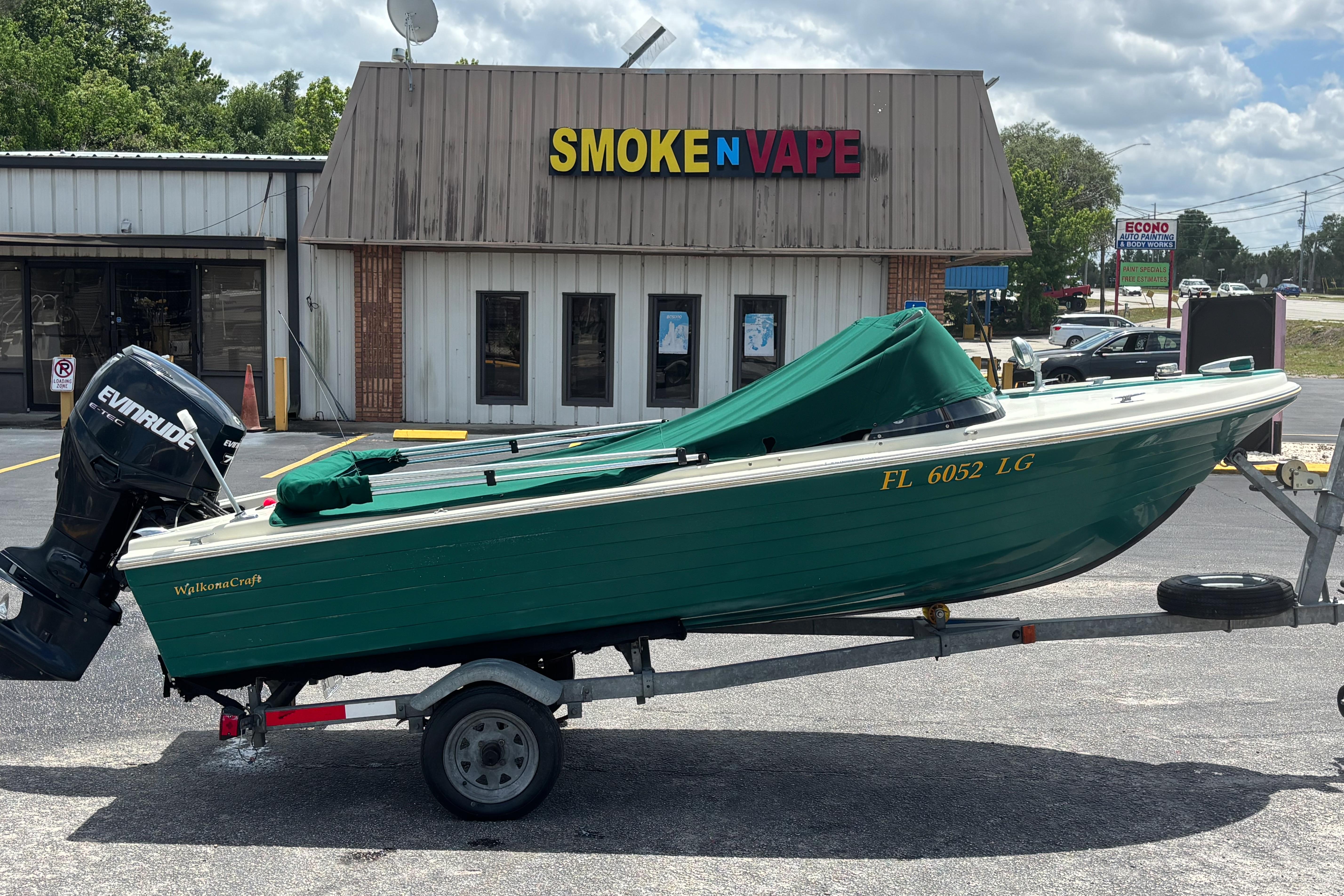 1966 Mohawk 15 boat on trailer outside Smoke N Vape shop.