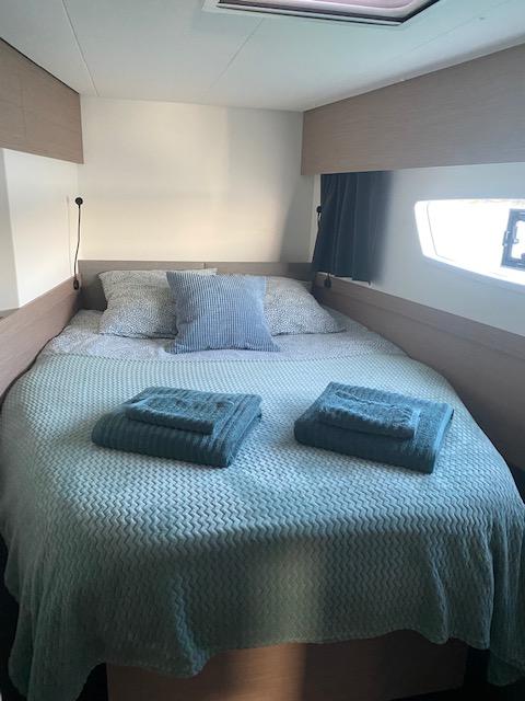 Cozy bedroom in 2022 Fountaine Pajot Elba 45 yacht with neatly arranged bedding.