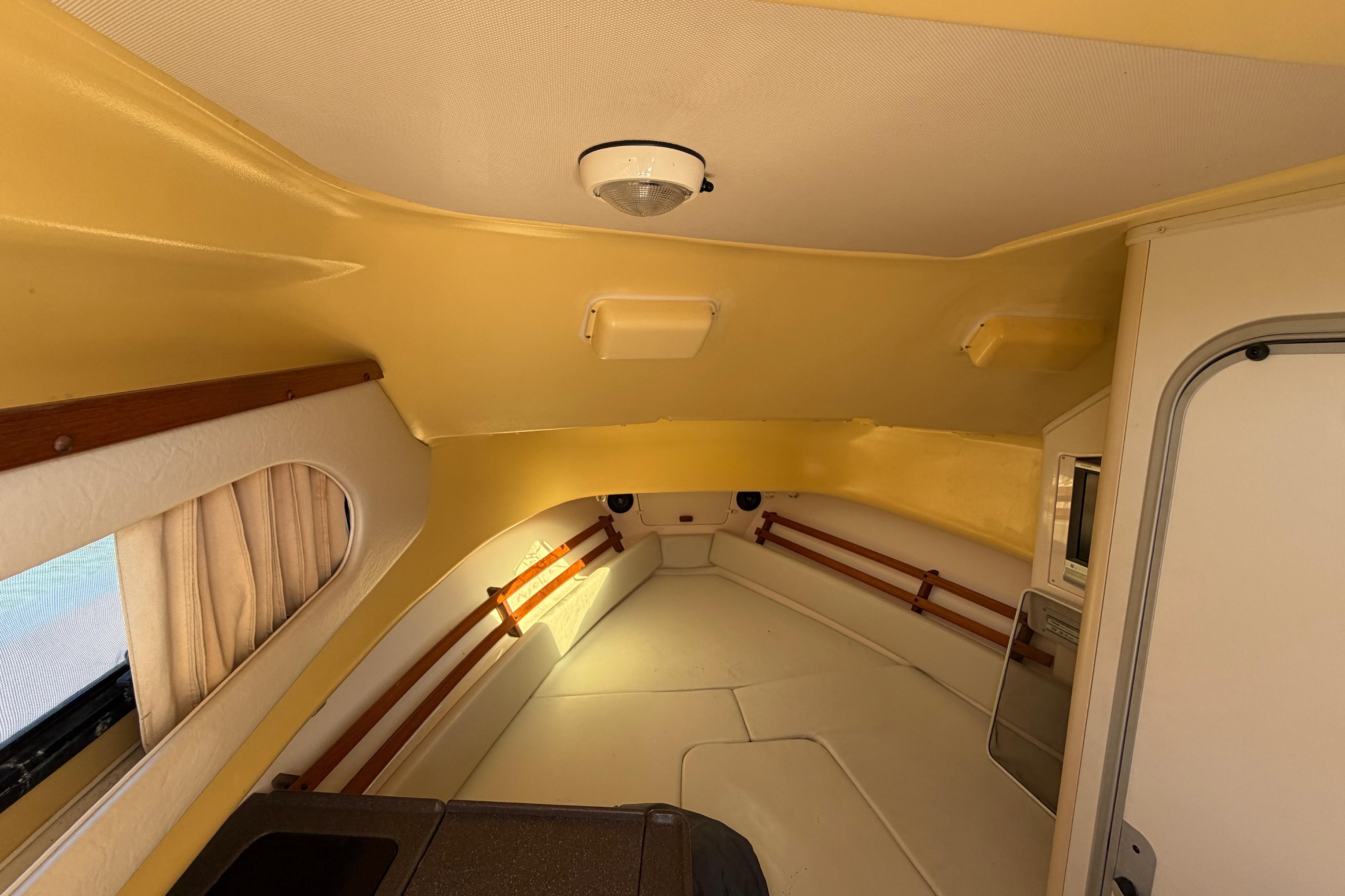 Interior cabin of 2006 Grady-White Sailfish 282 boat, featuring cozy seating and storage.