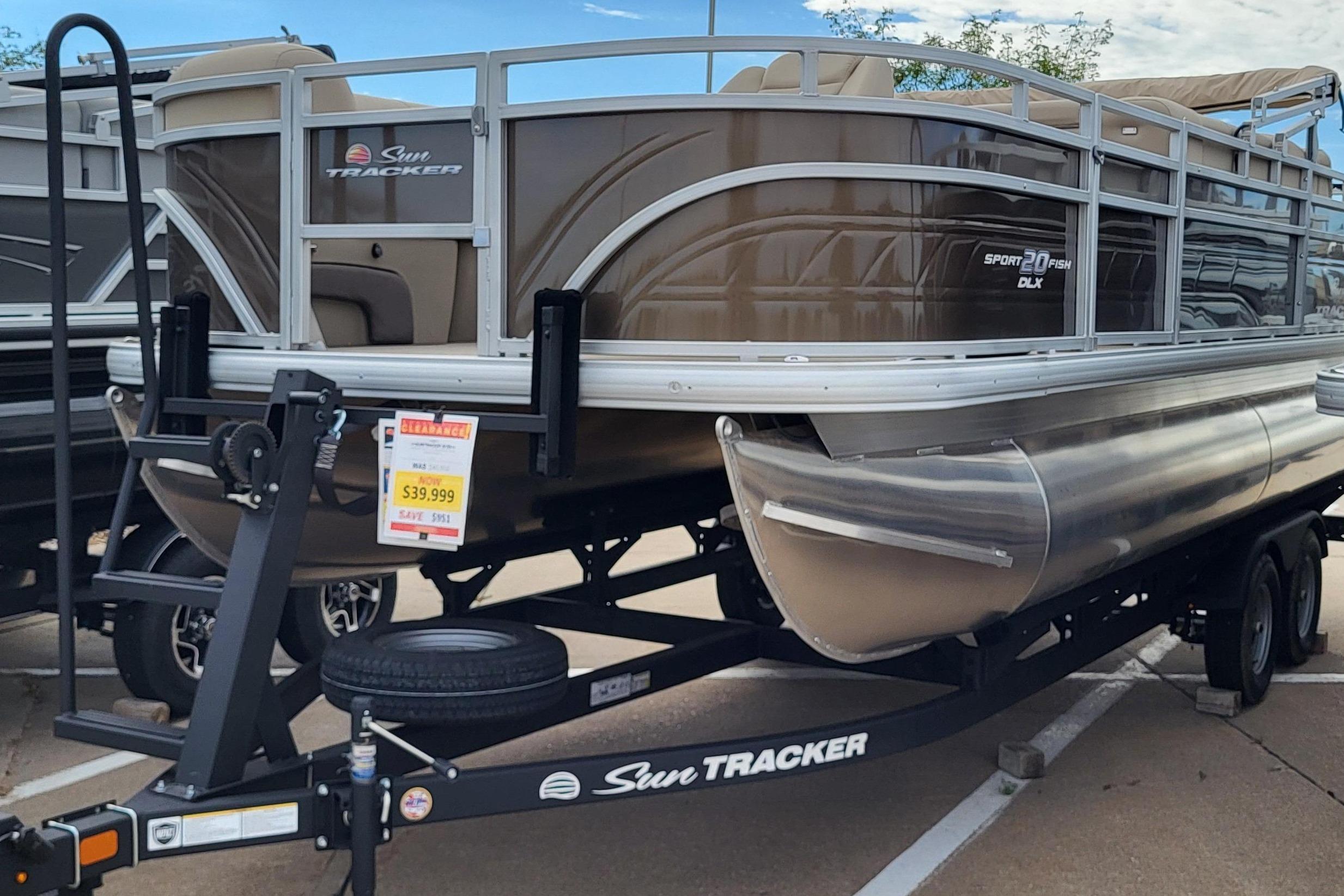2025 Sun Tracker SportFish 20 DLX pontoon boat on trailer, displayed outdoors.