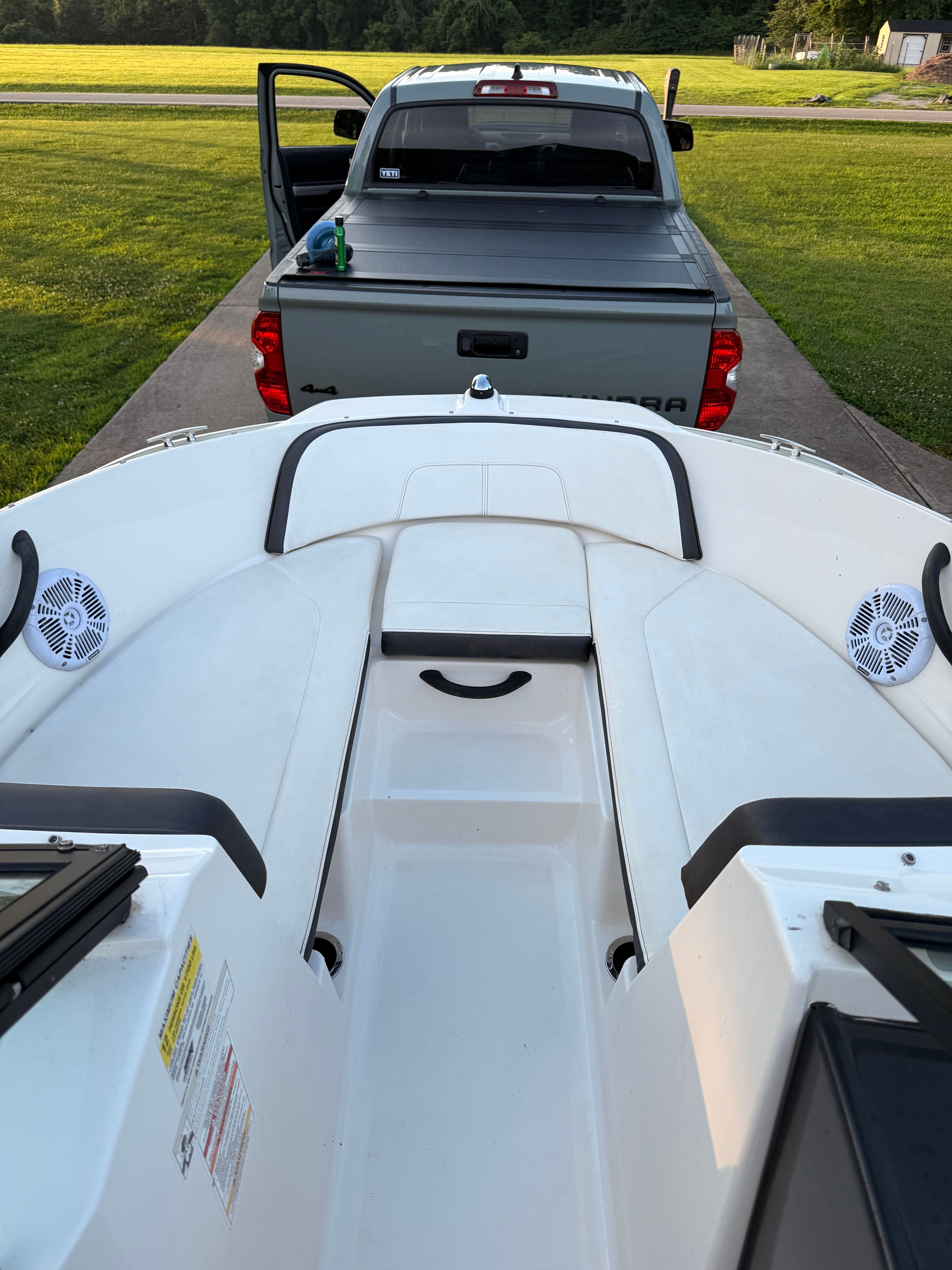 A 2016 Sea Ray SPX 210 Outboard on a trailer in front of a pickup truck.