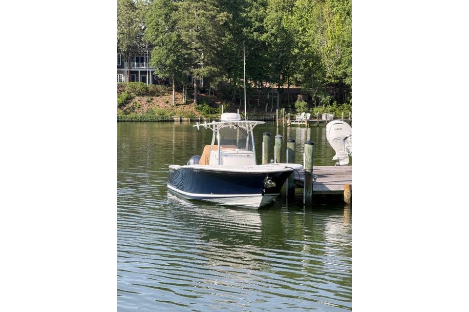 2014 Southport 29 FE boat docked on a serene lake with lush greenery.