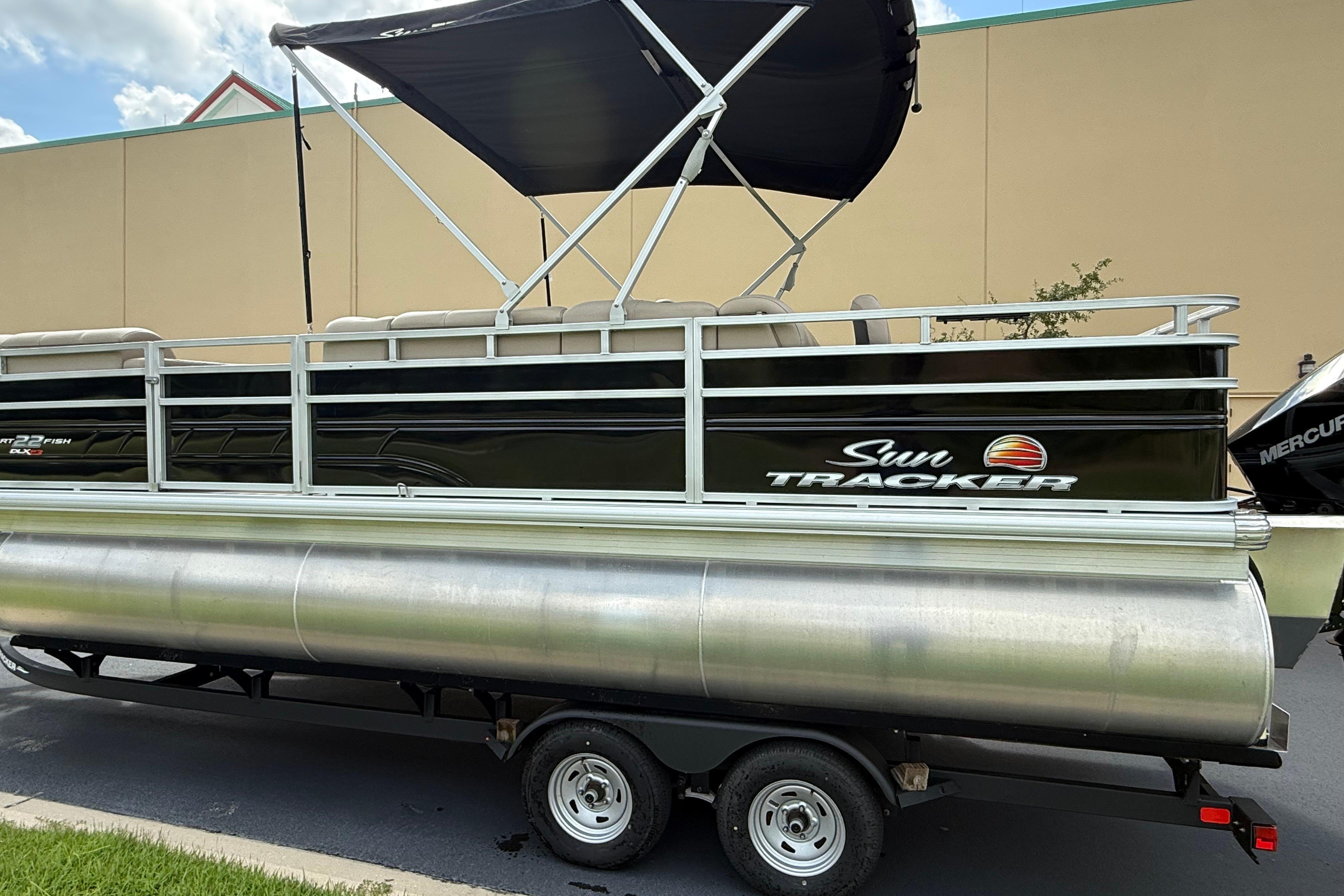 2024 Sun Tracker SportFish 22 XP3 pontoon boat with canopy on trailer.