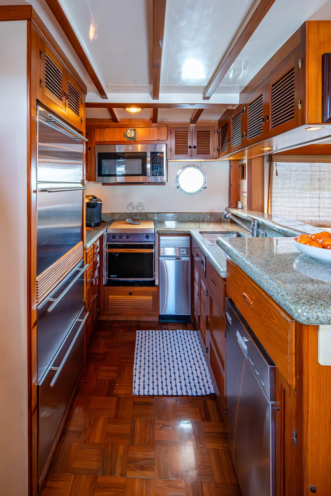Galley kitchen in 2000 Kadey-Krogen 48 North Sea yacht with wood cabinetry and modern appliances.