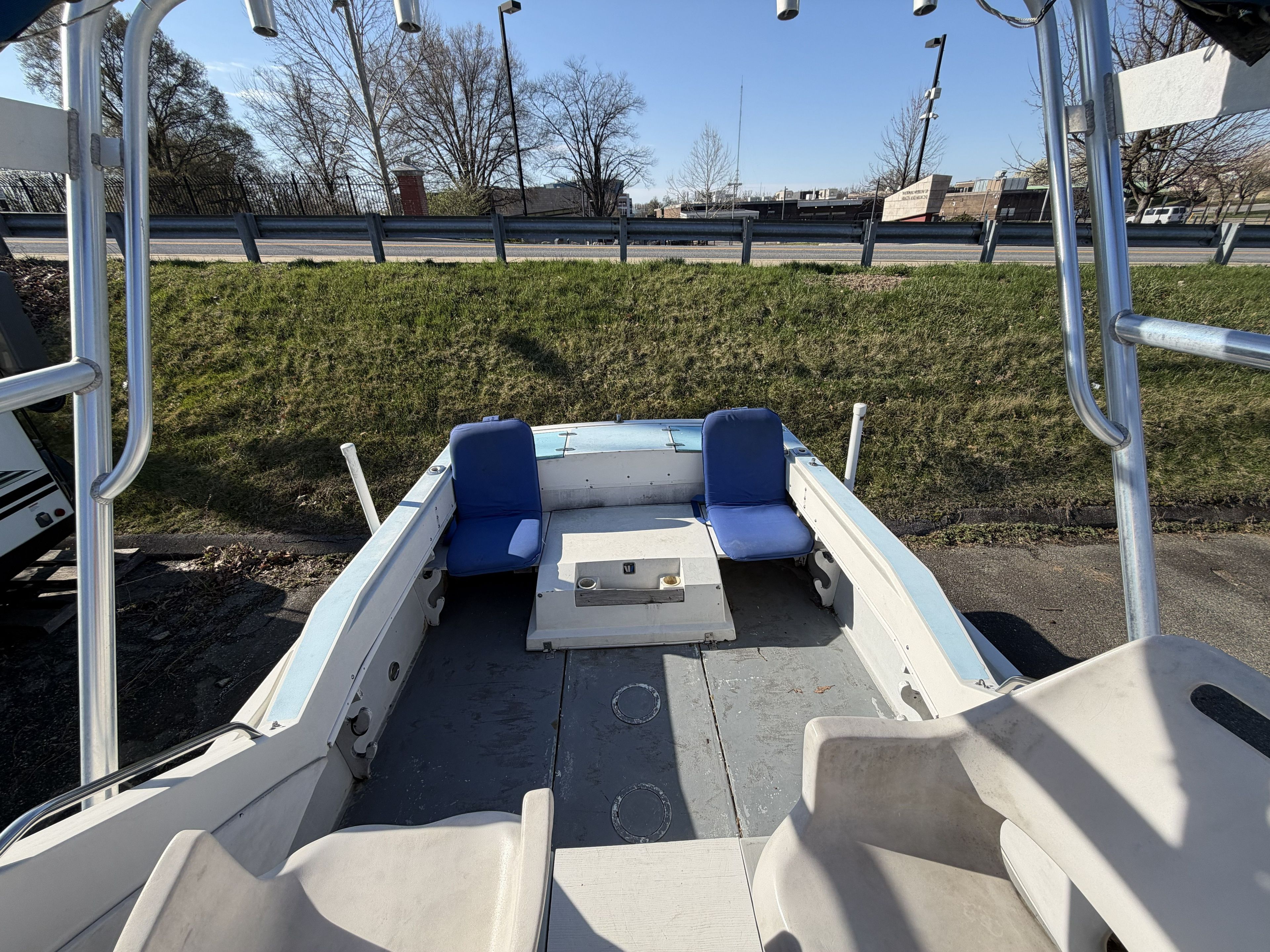 The image shows the cockpit of a 1989 Wellcraft 250 Sportsman with blue seats.