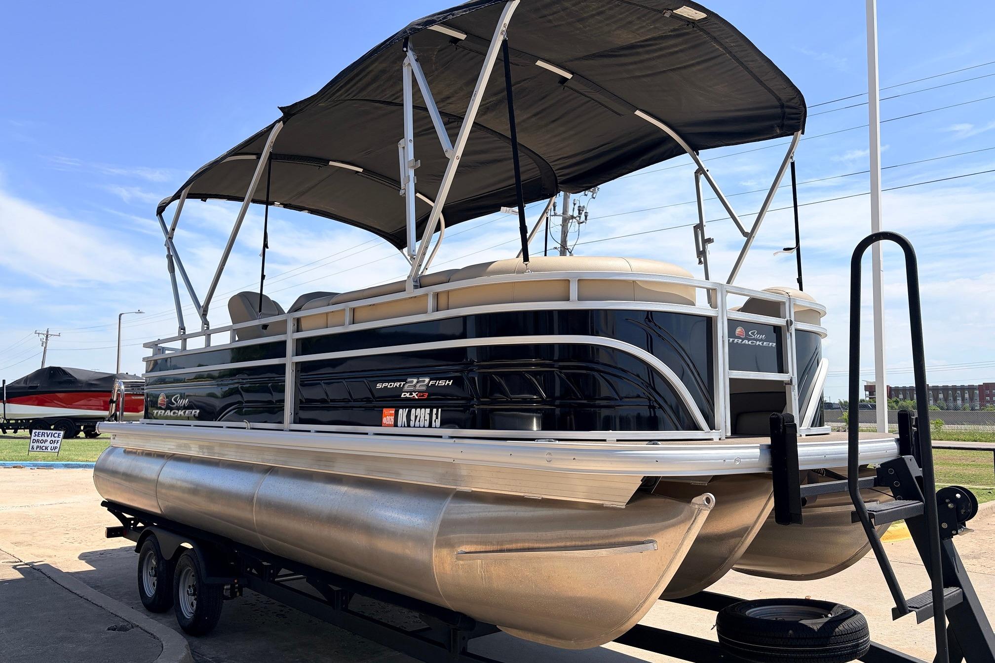 2024 Sun Tracker SportFish 22 XP3 pontoon boat with canopy on trailer.
