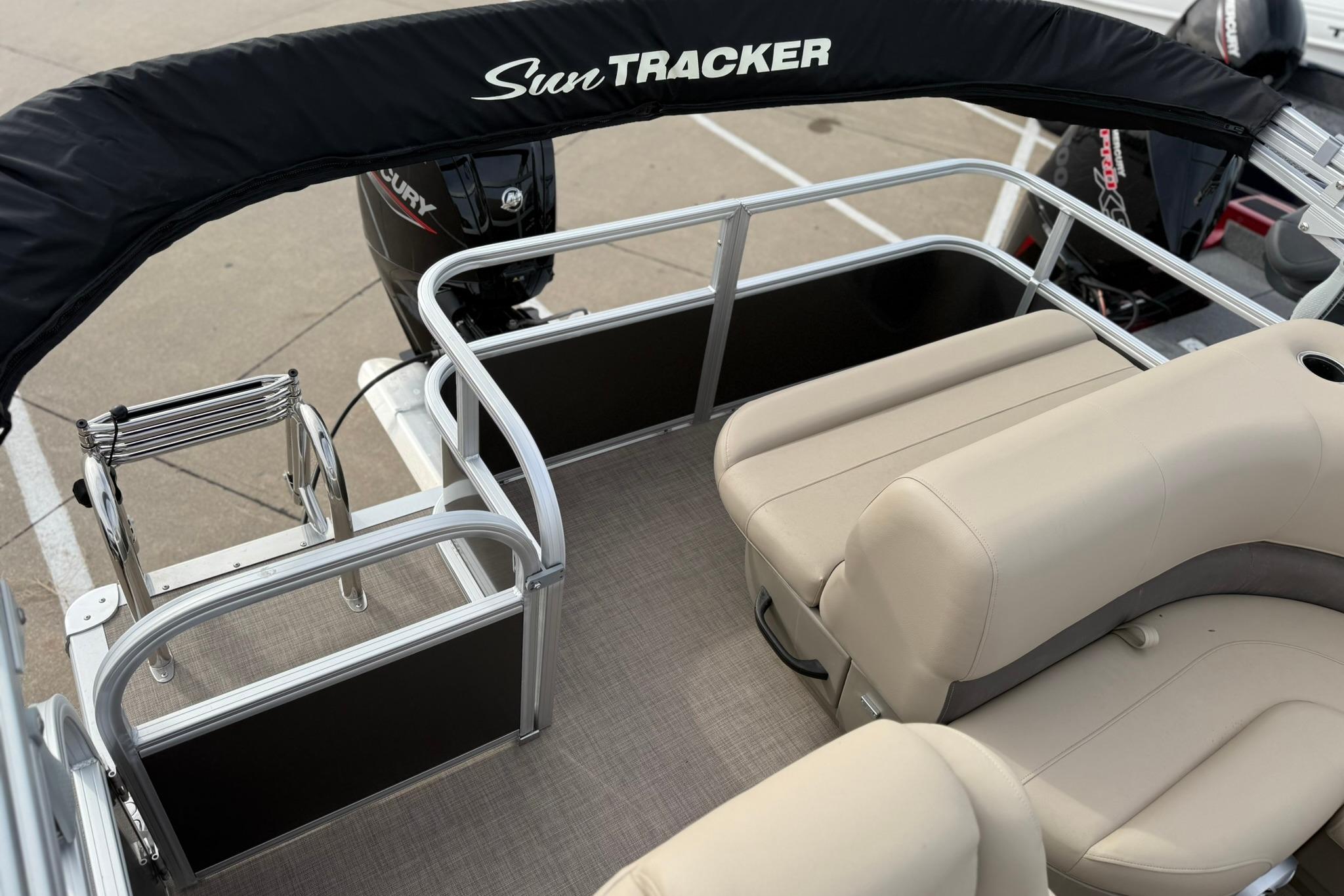 2025 Sun Tracker Party Barge 18 DLX interior with seating and motor, showcasing comfort and design.