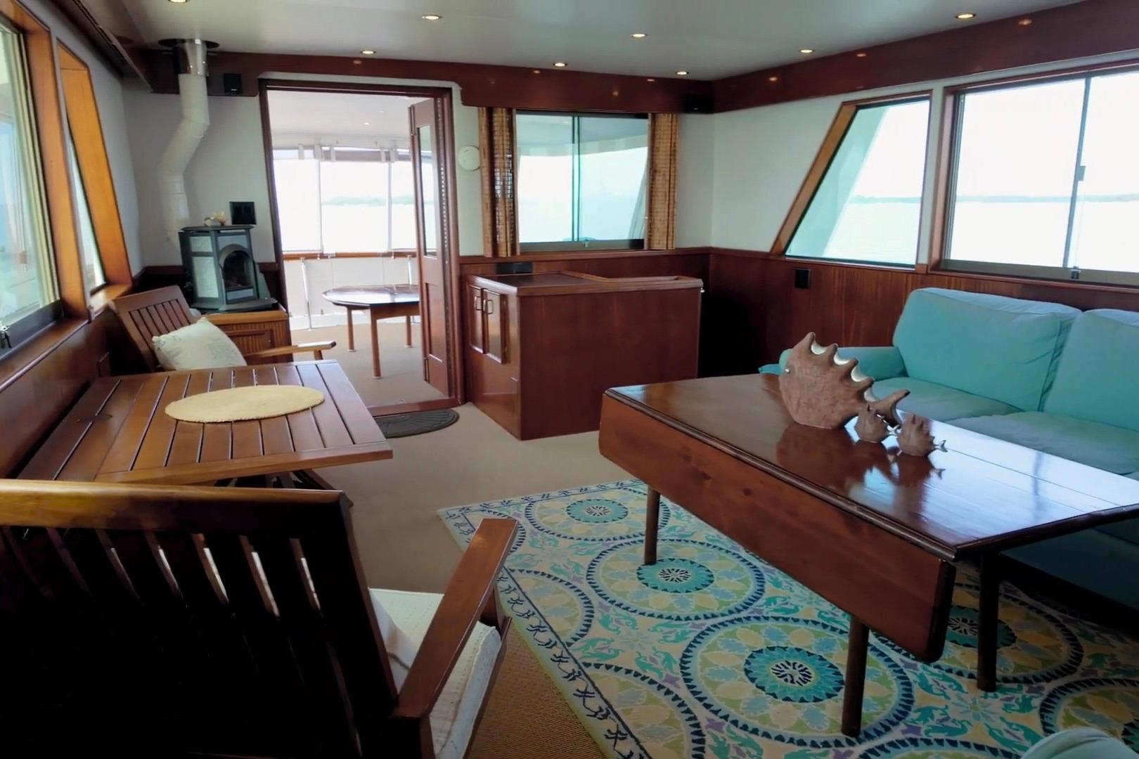 Interior of 1980 Hatteras 70 Motor Yacht with wooden furniture and sea view.