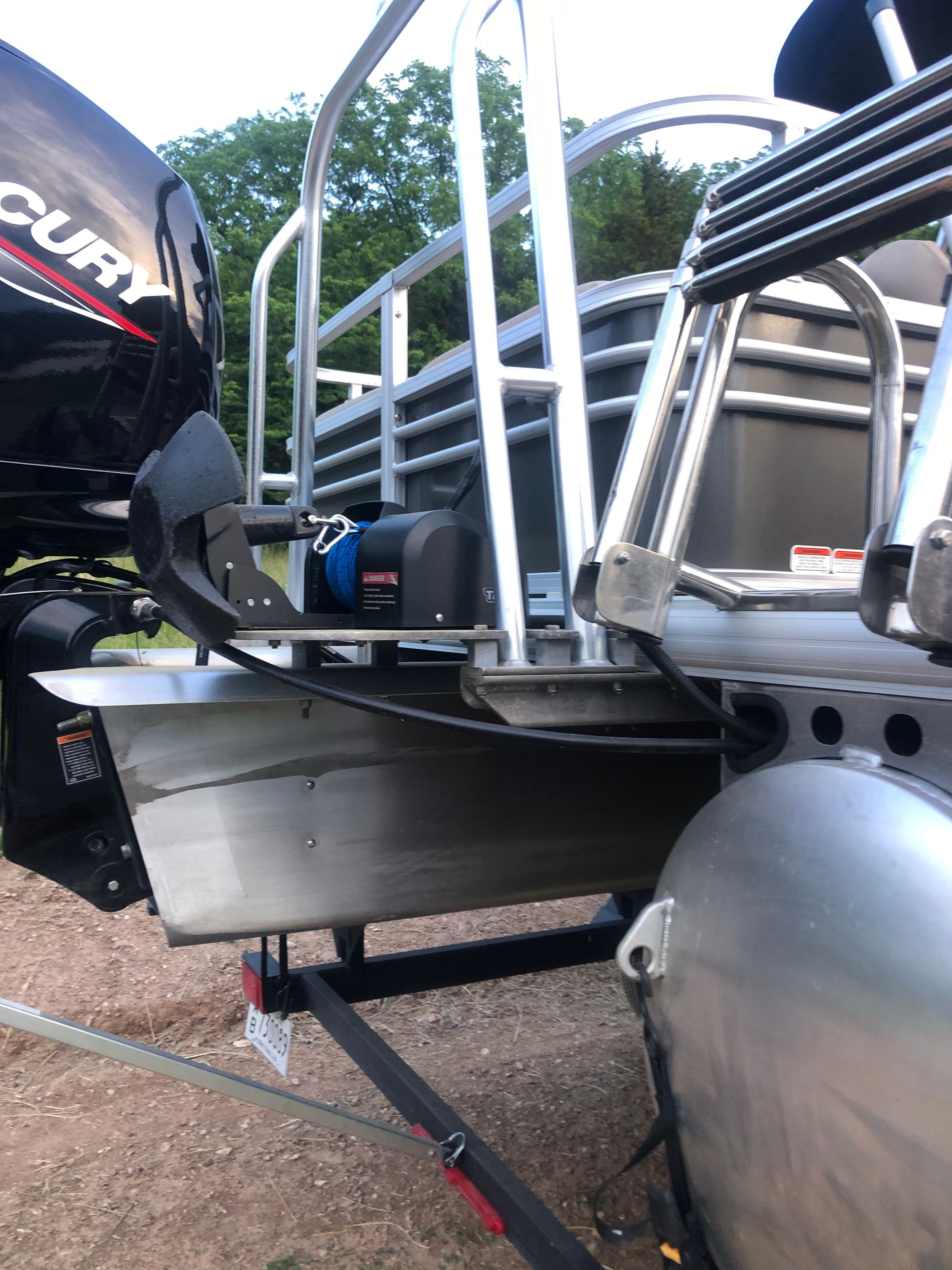 The image shows the rear of a Sun Tracker Fishin' Barge 22 DLX boat with a Mercury engine.