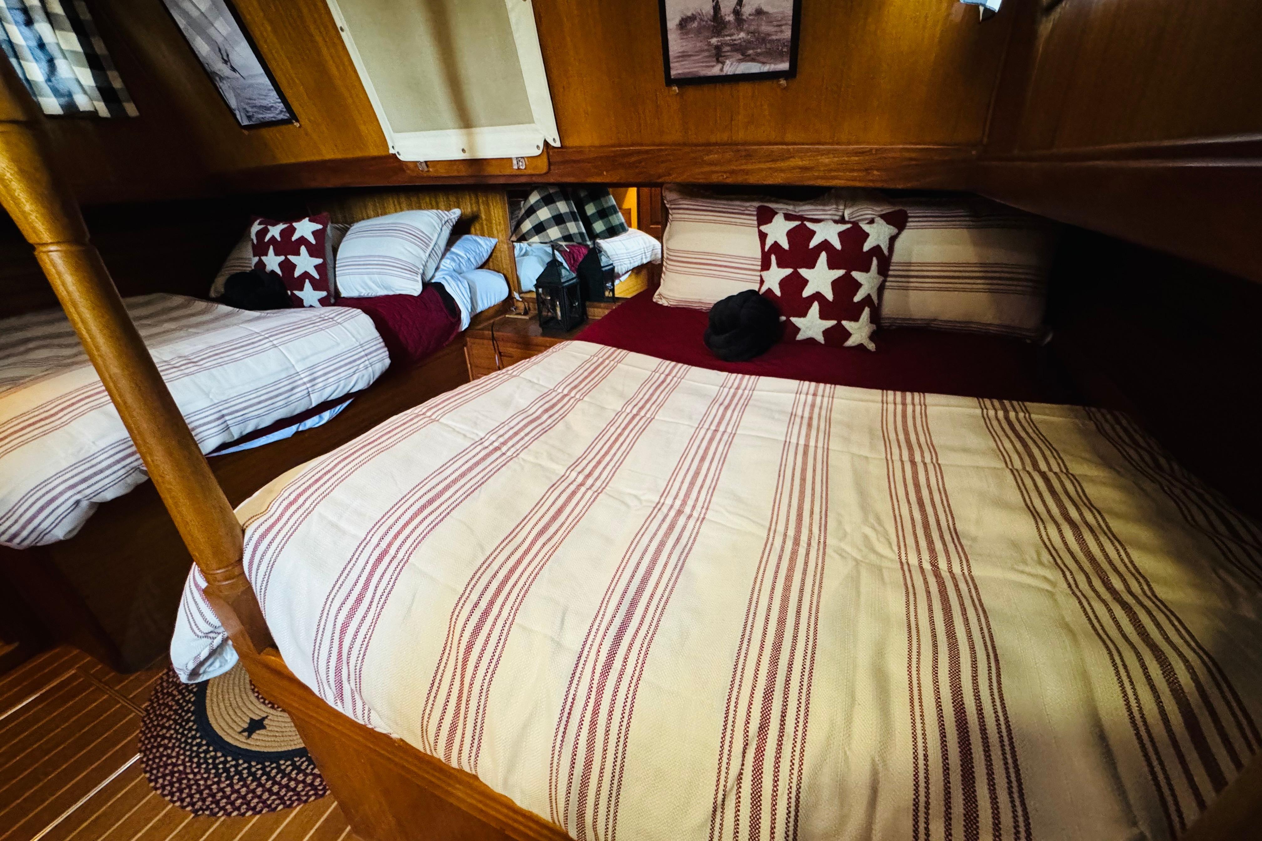 Cozy cabin interior of 1978 Californian 42 LRC with striped bedding and star-patterned pillows.