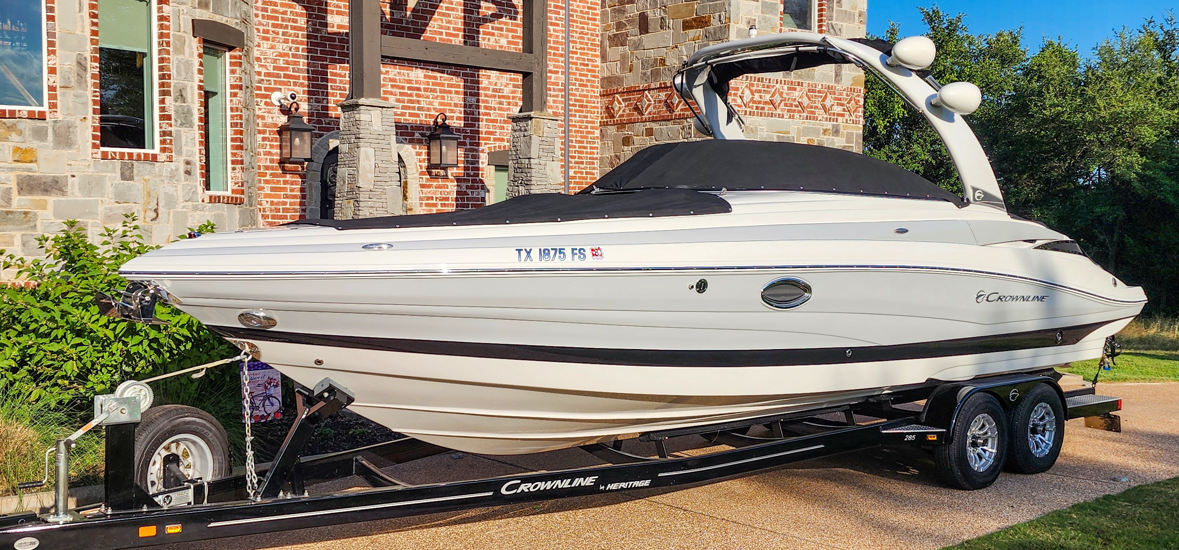 A 2017 Crownline 285SS on a trailer in front of a brick building.