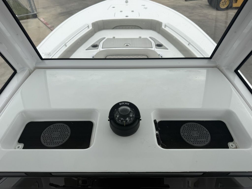 The image shows the cockpit of a Sportsman Masters 247OE Bay Boat with a compass.