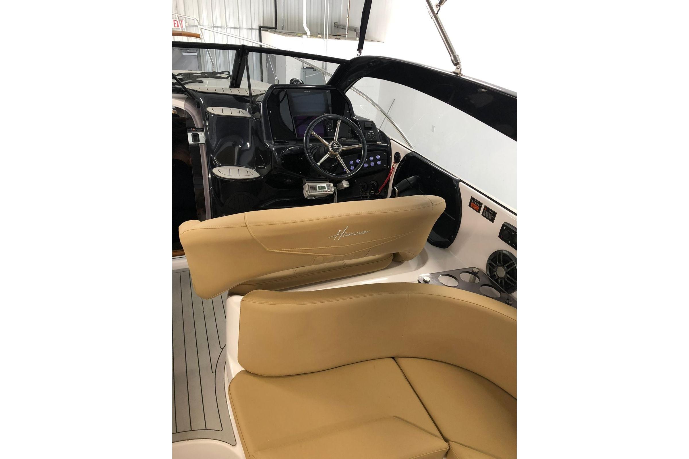 2024 Hanover 305 boat interior with tan seating and modern dashboard controls.