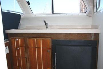2005 Ocean Sport Roamer 30' interior with wooden cabinetry and sink.