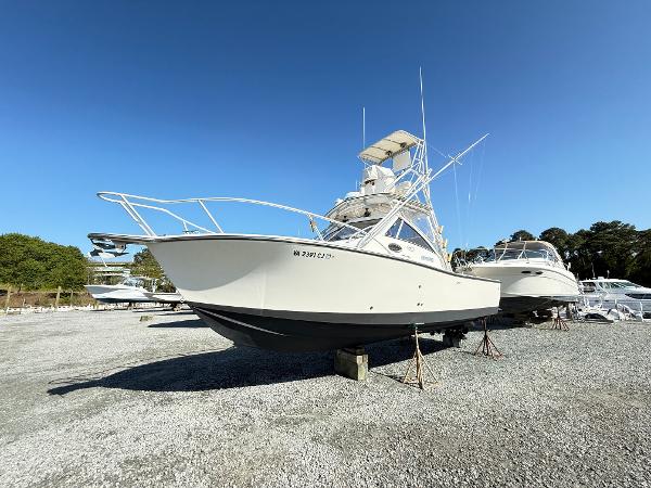 2001 Albemarle 280 Express Sport Fisherman boat on gravel lot under clear blue sky.