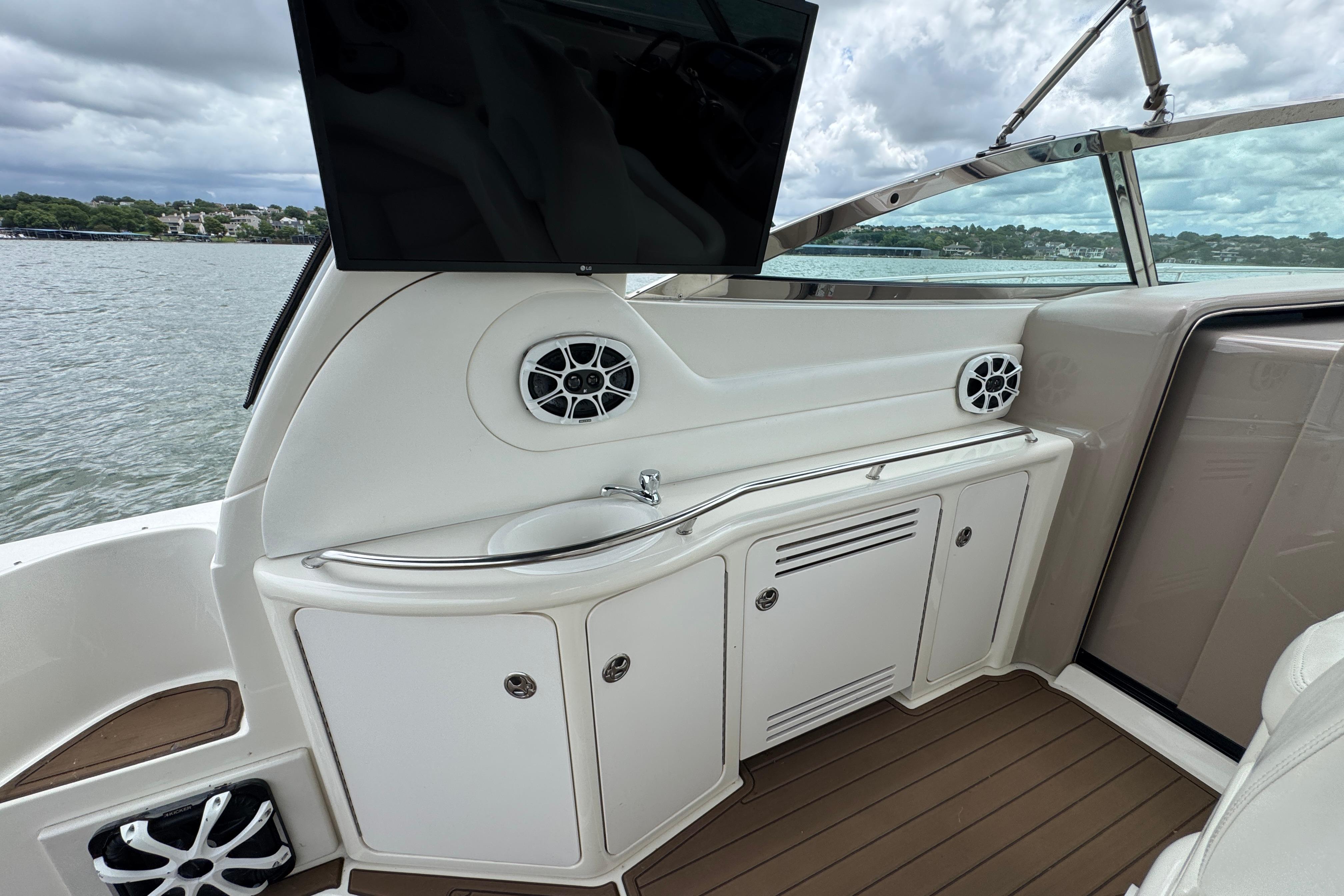 2001 Sea Ray 380 Sundancer interior with sink, cabinets, and speakers, overlooking water.