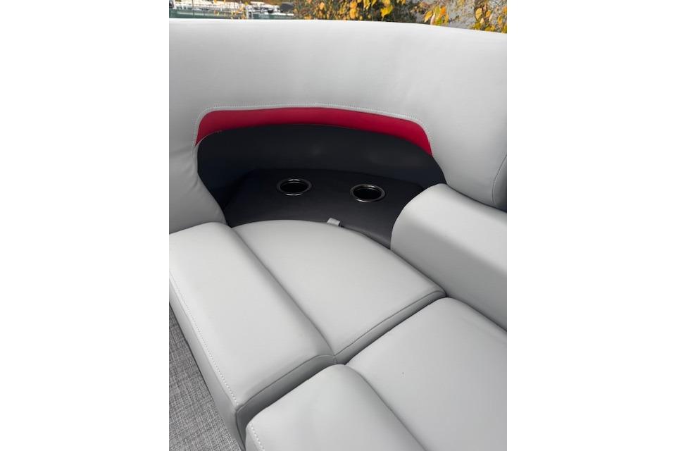 2026 Sun Tracker Party Barge 22 DLX interior seating with cup holders and red accent.