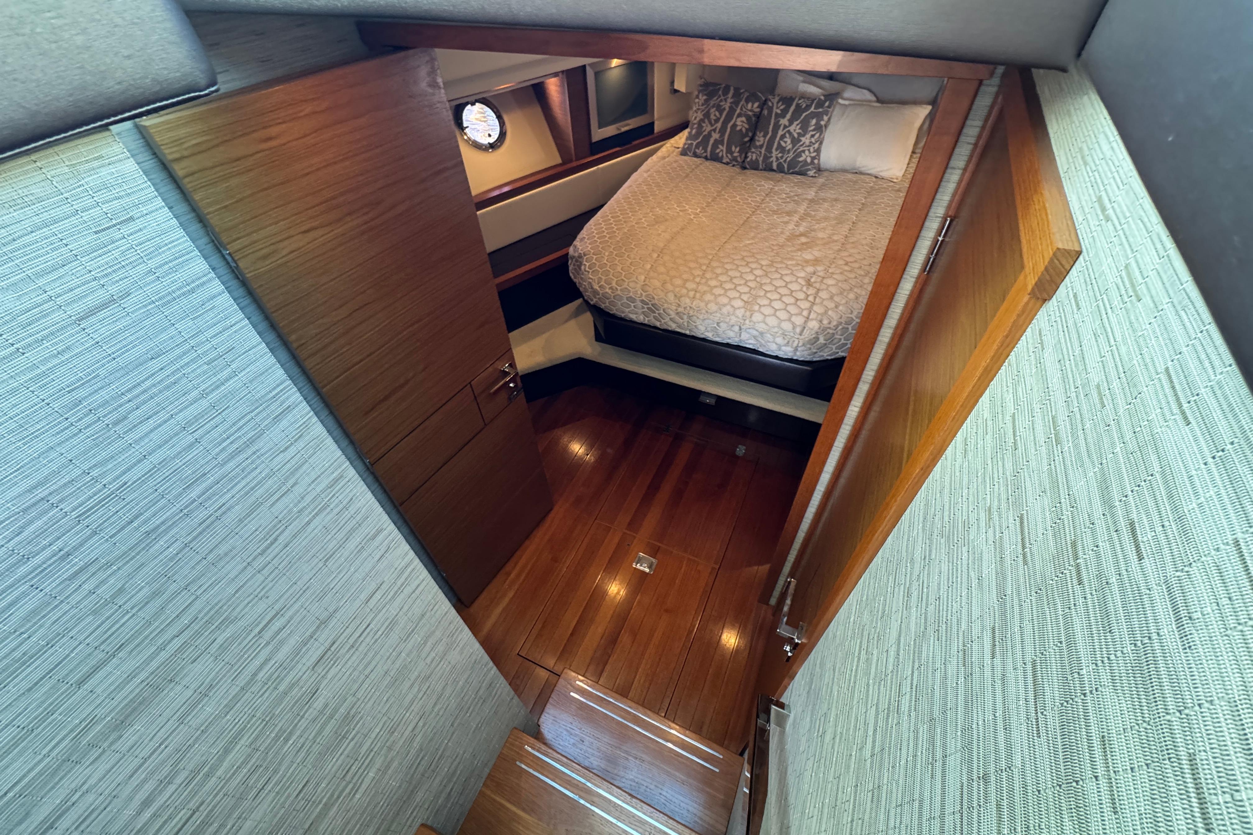 Interior cabin of 2016 Tiara Yachts C44 Coupe with wooden flooring and cozy bed.