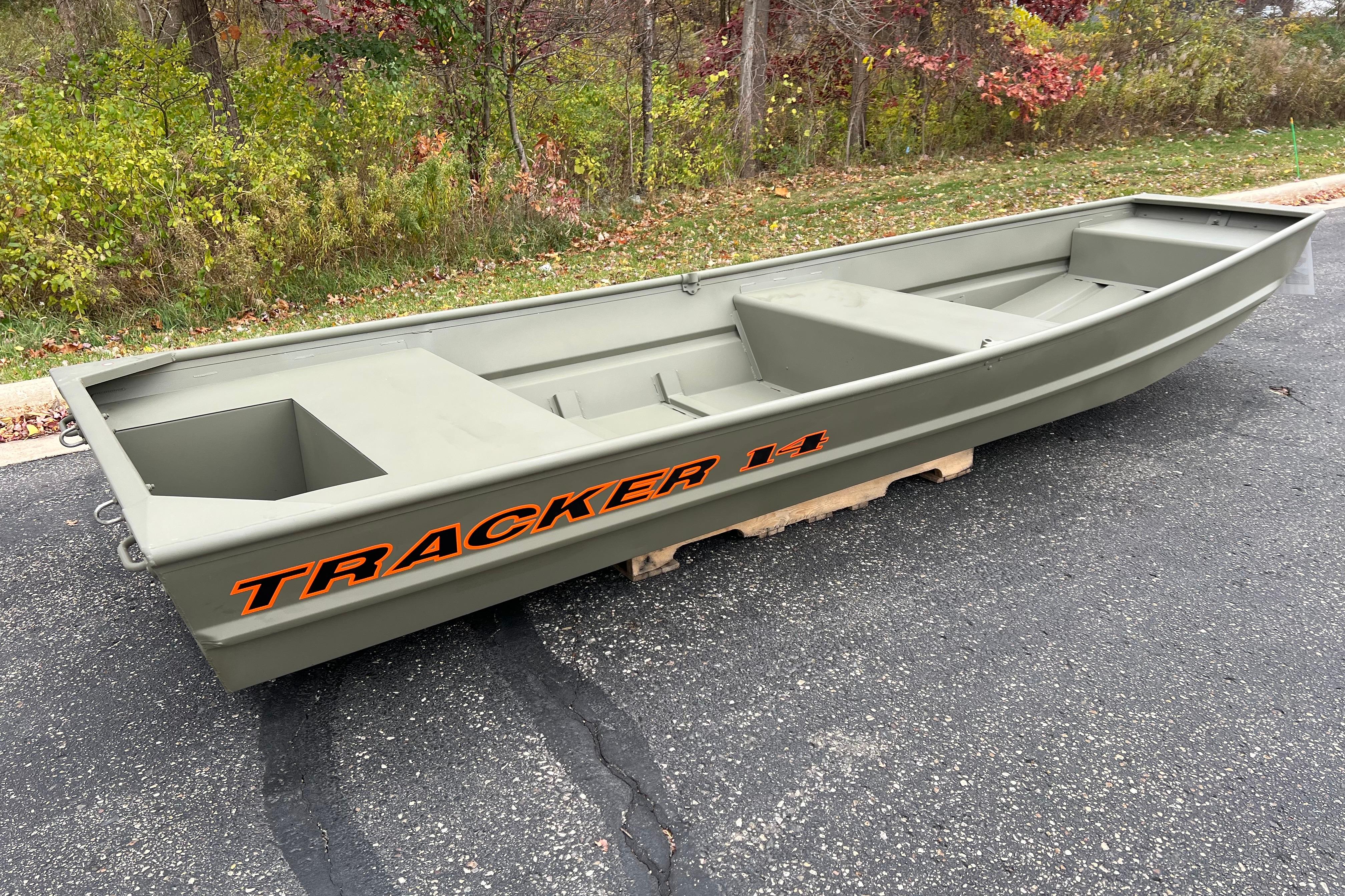 2026 Tracker Grizzly 14 Jon boat on pavement, surrounded by autumn foliage.