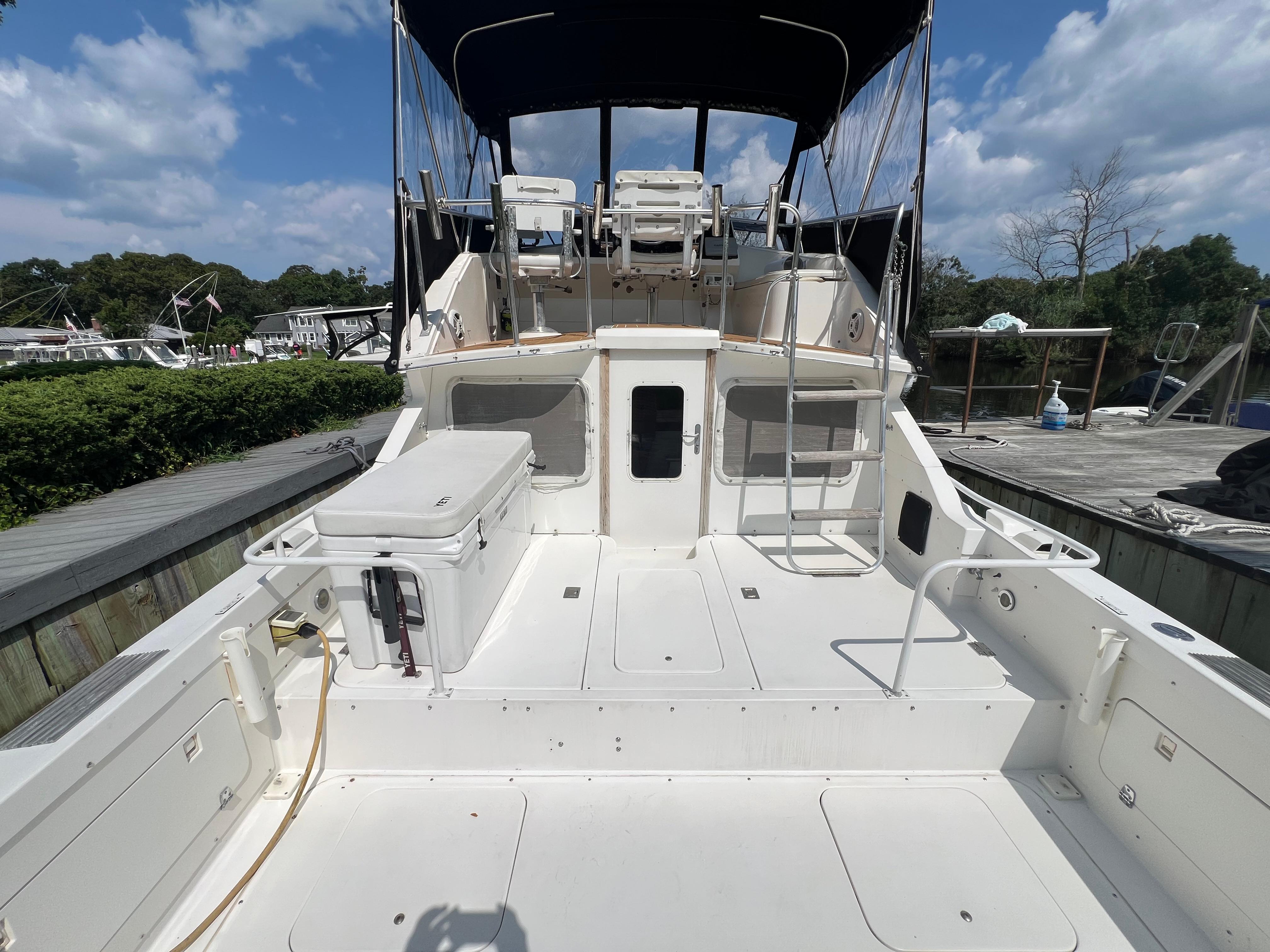 1990 Bertram 28 Flybridge boat with spacious deck and flybridge under a clear sky.