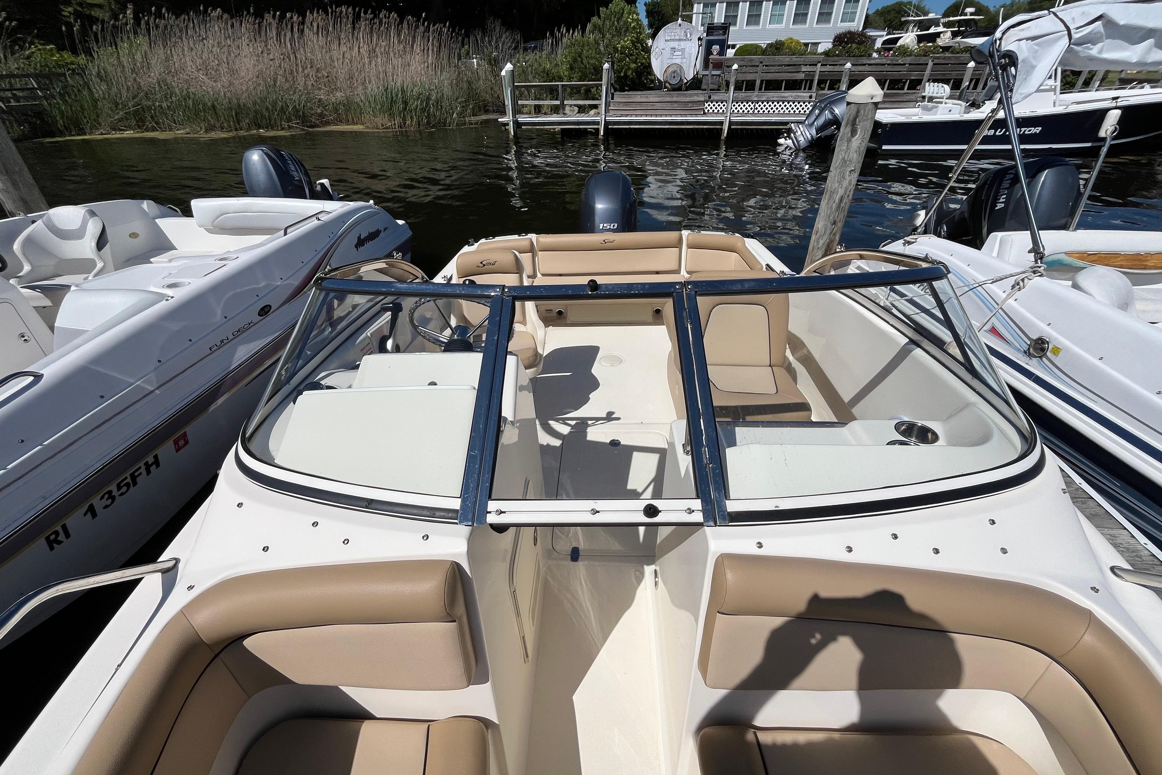 2017 Scout 210 Dorado boat docked, featuring tan seating and sleek design.