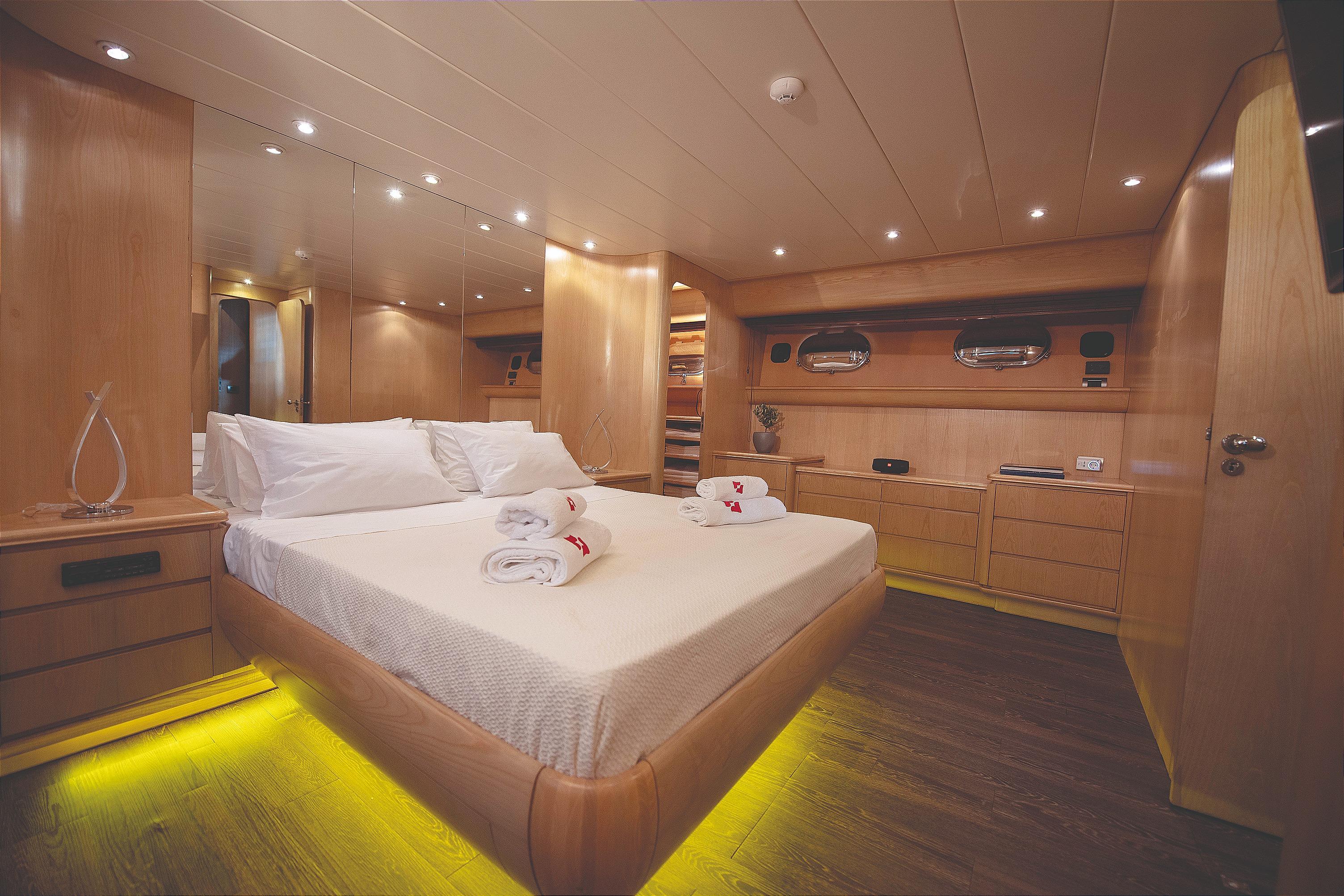 Luxurious Canados 88 yacht bedroom interior, 1992 model, featuring elegant wood finishes and ambient lighting.