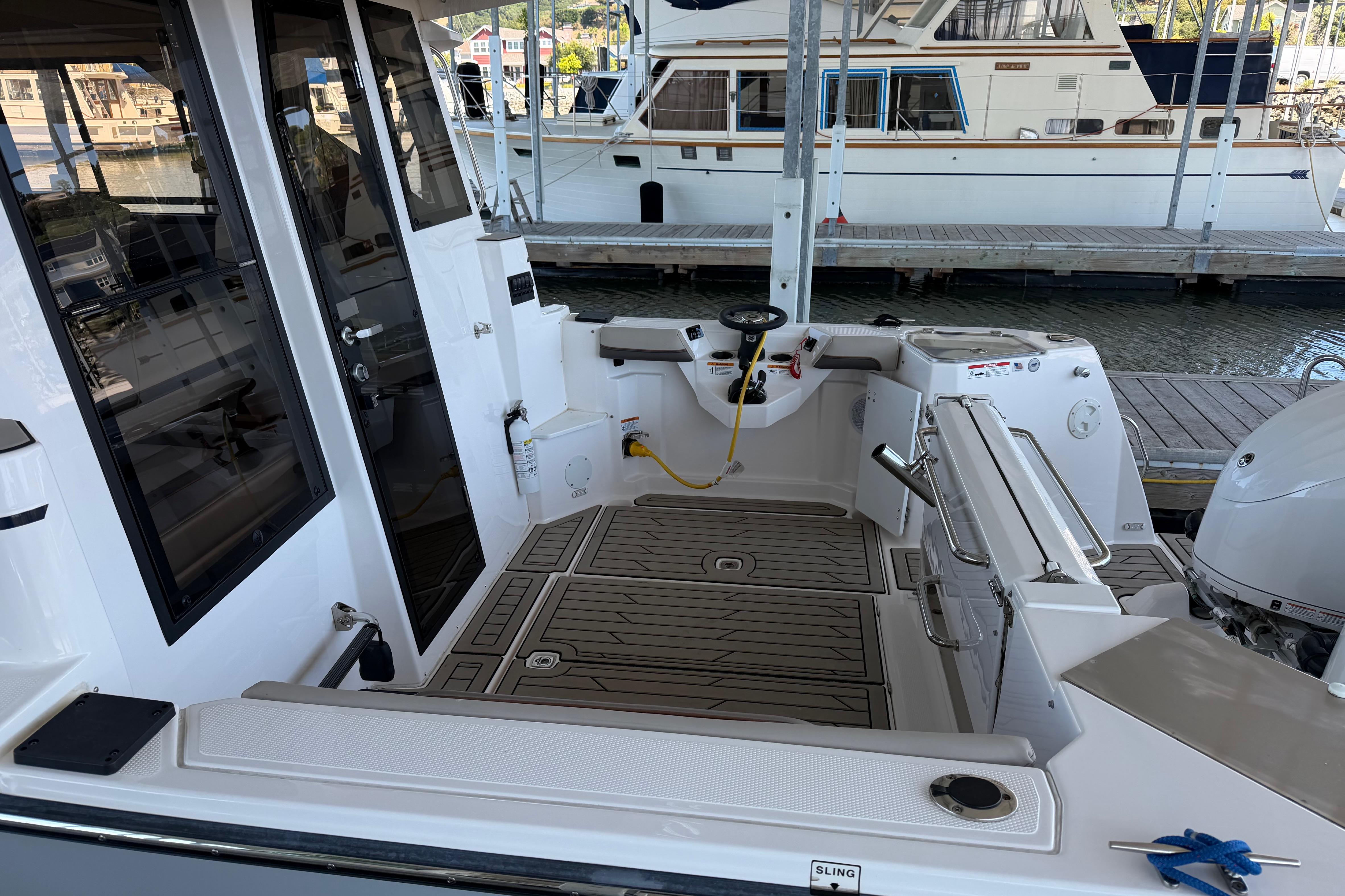 2023 Cutwater C-288 Coupe boat interior at dock, showcasing cockpit and seating area.