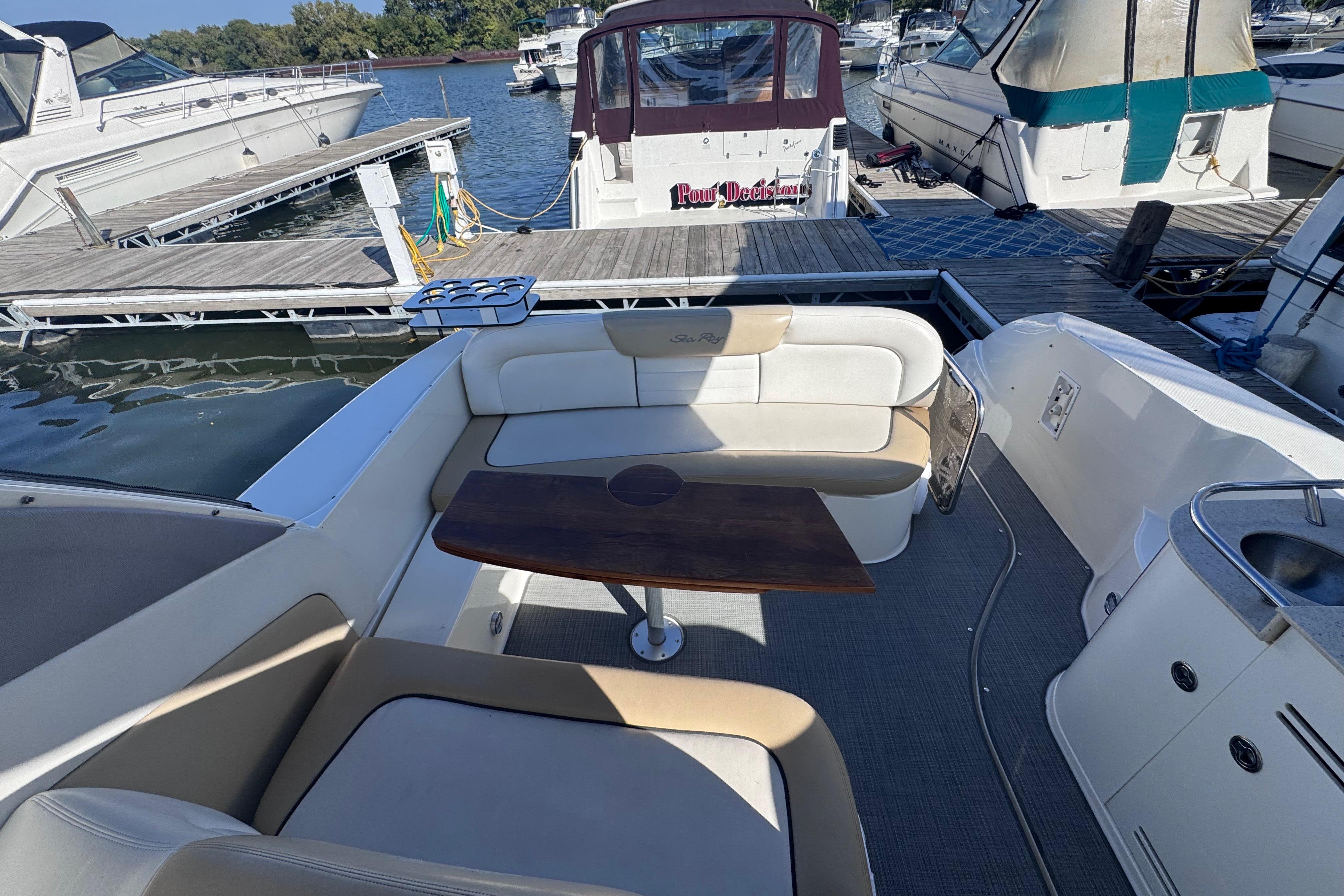 2008 Sea Ray 350 Sundancer interior with seating and table at marina dock.