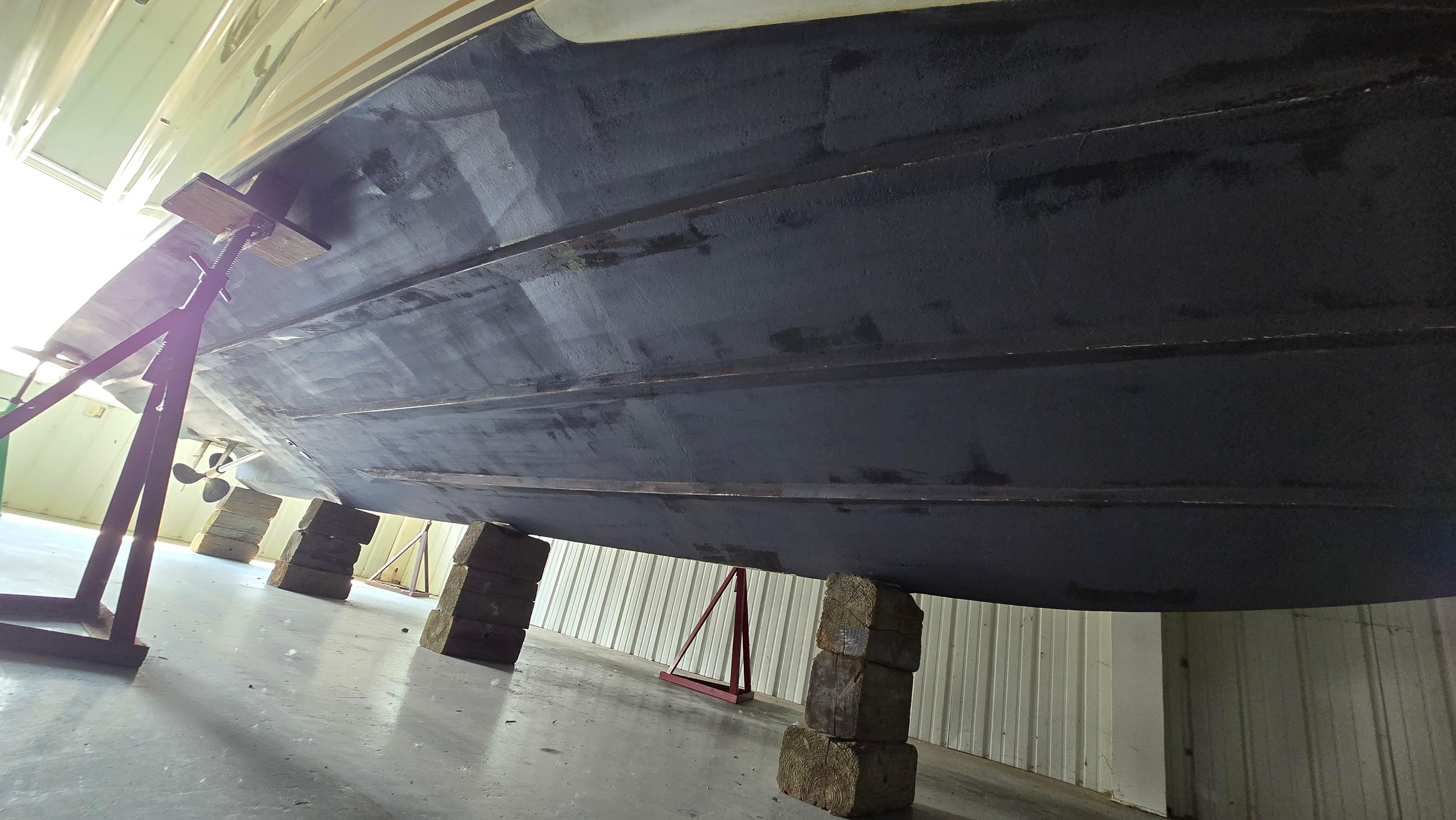 2000 Sea Ray 310 Sundancer boat hull on blocks in storage facility.