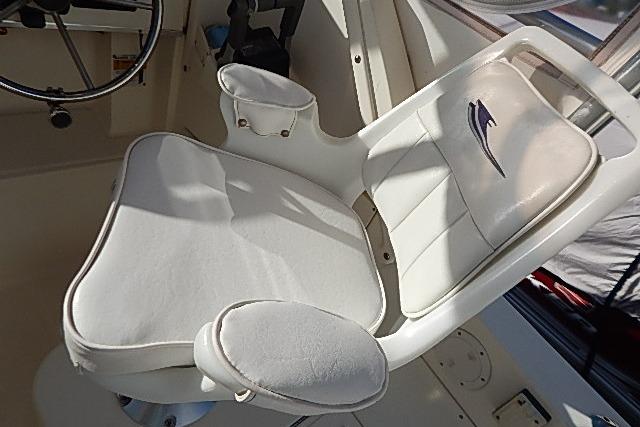 Captain's chair in 2003 World Cat 270 EC boat cockpit, featuring white upholstery and armrests.